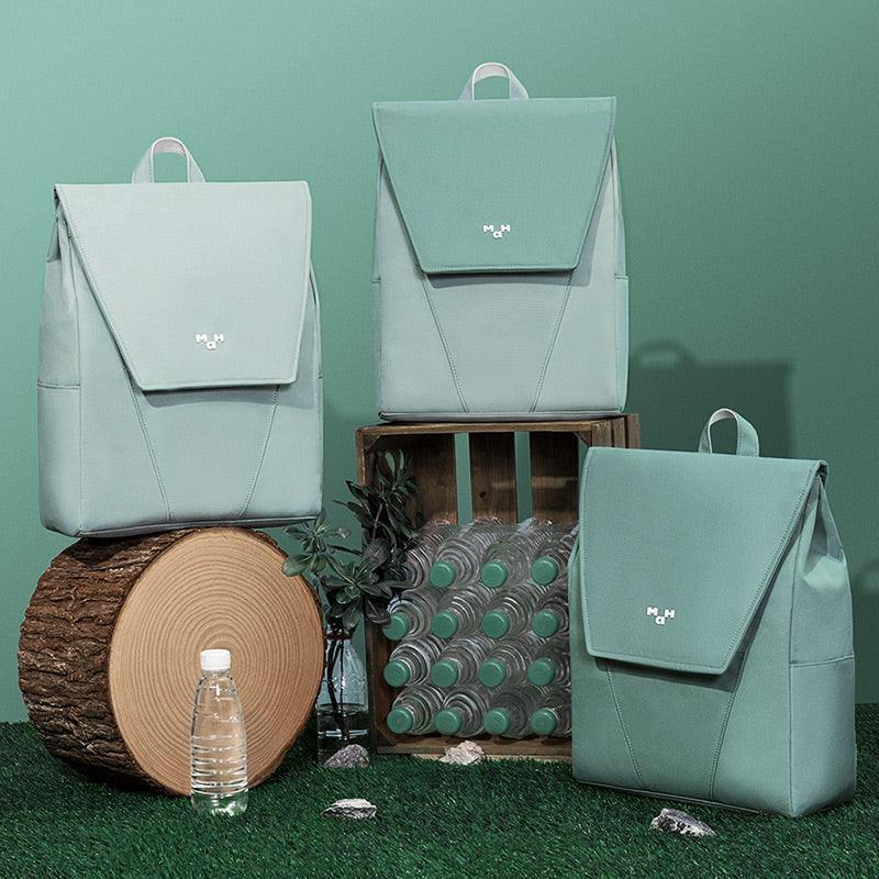 Mint green backpacks with minimalist design, displayed on wood and grass, ideal for everyday use and travel.