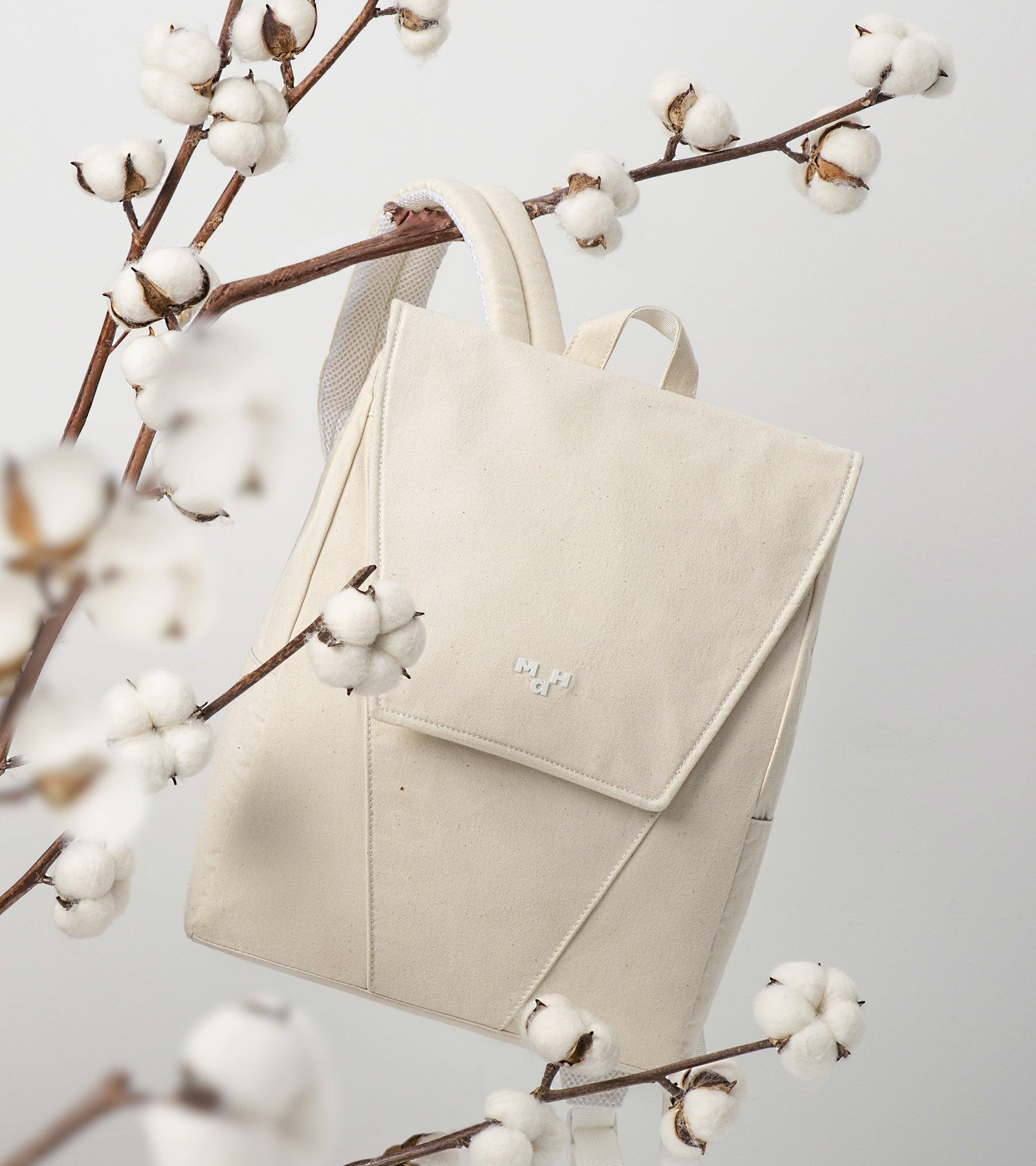 Cream canvas backpack with cotton branches, minimalist design, lifestyle accessory