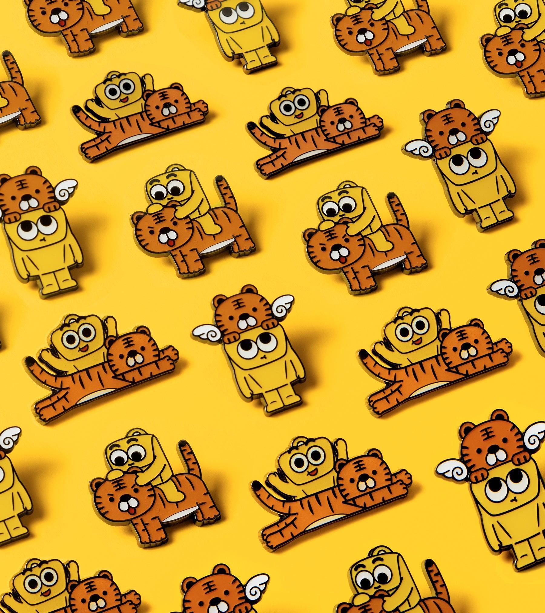 Cute cartoon tiger and bear enamel pins on yellow background, fun accessories for bags and backpacks