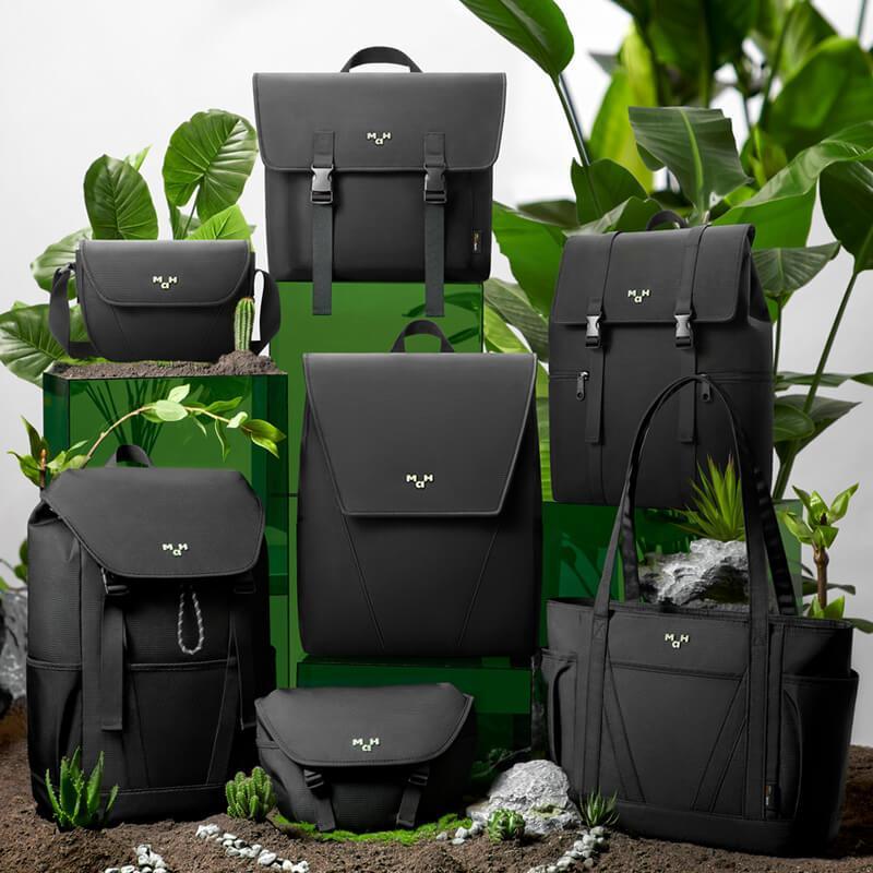 Stylish black backpacks, totes & crossbody bags with minimalist design, displayed with green plants for modern lifestyle