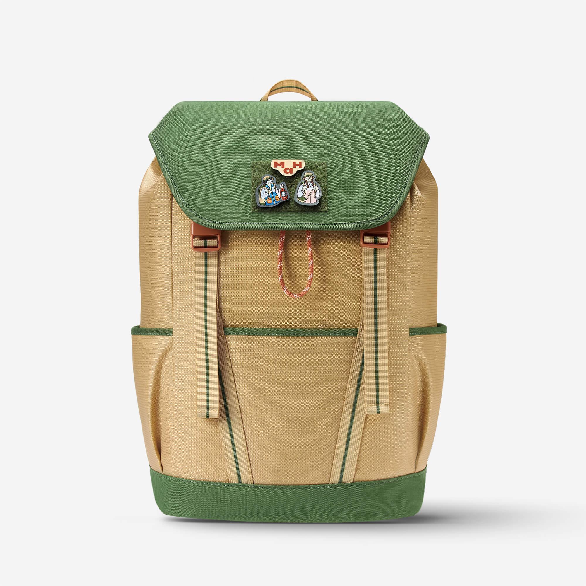 Green and beige backpack with character patches, adjustable straps, and front pockets for daily use or travel.