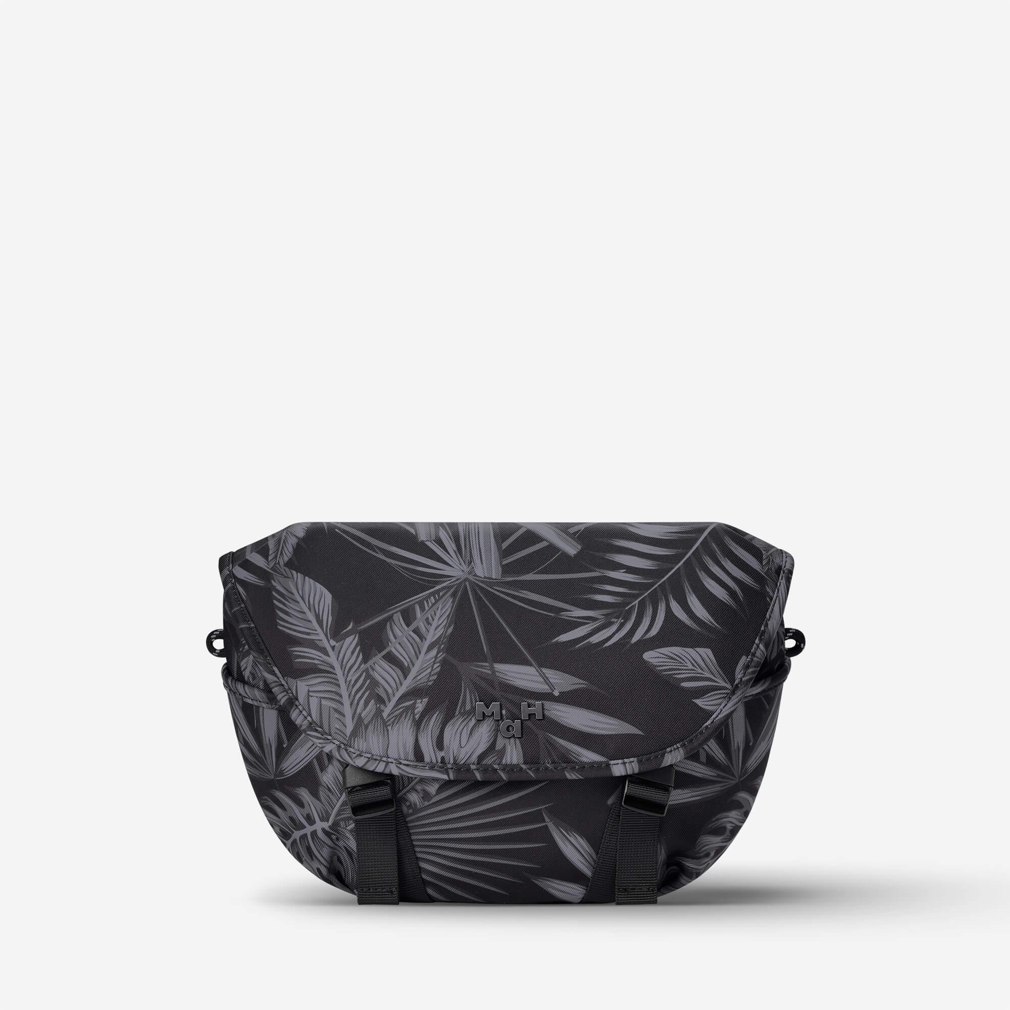 Black palm leaf print messenger bag with adjustable straps and front logo