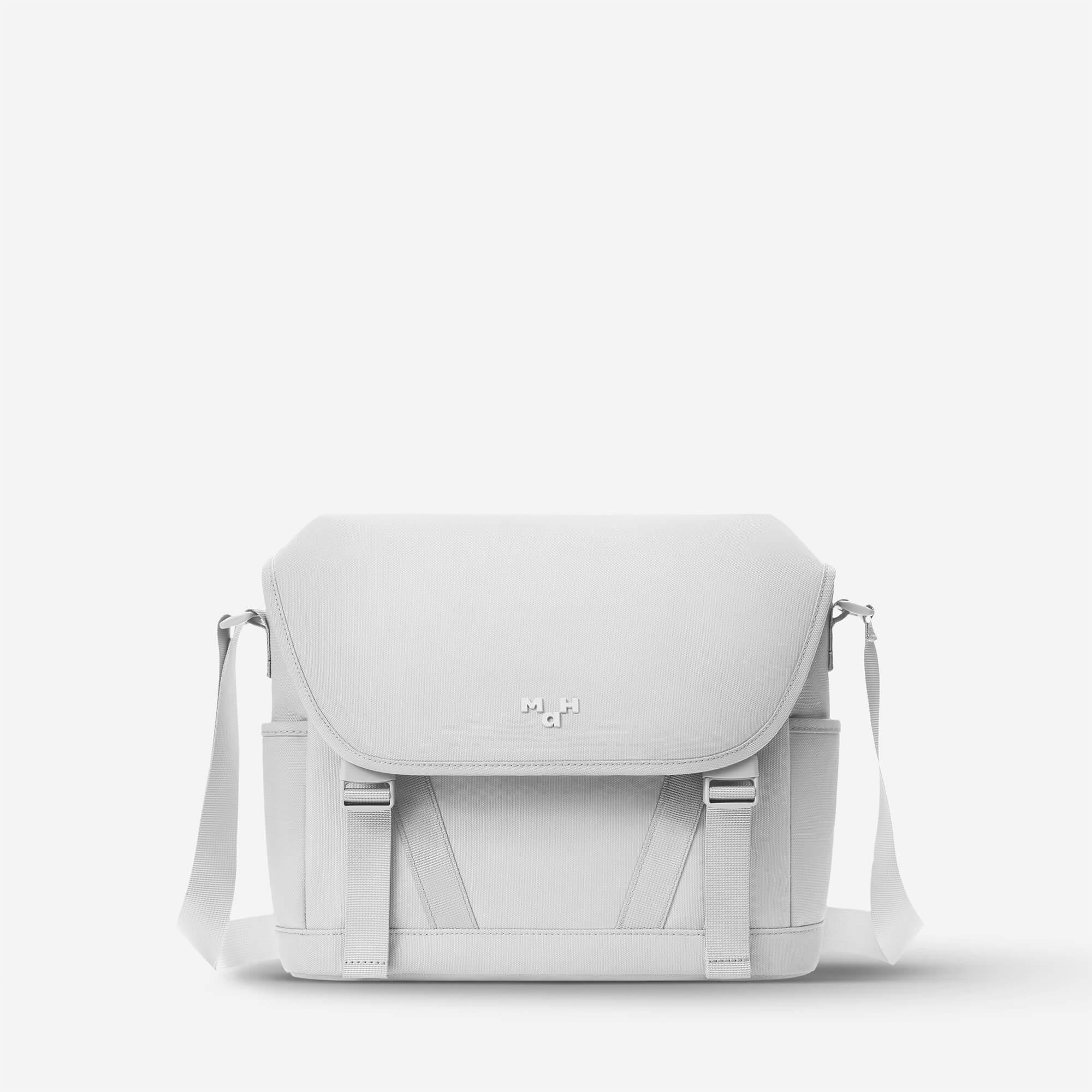 Light gray minimalist crossbody bag with adjustable strap and front flap closure, ideal for everyday use.
