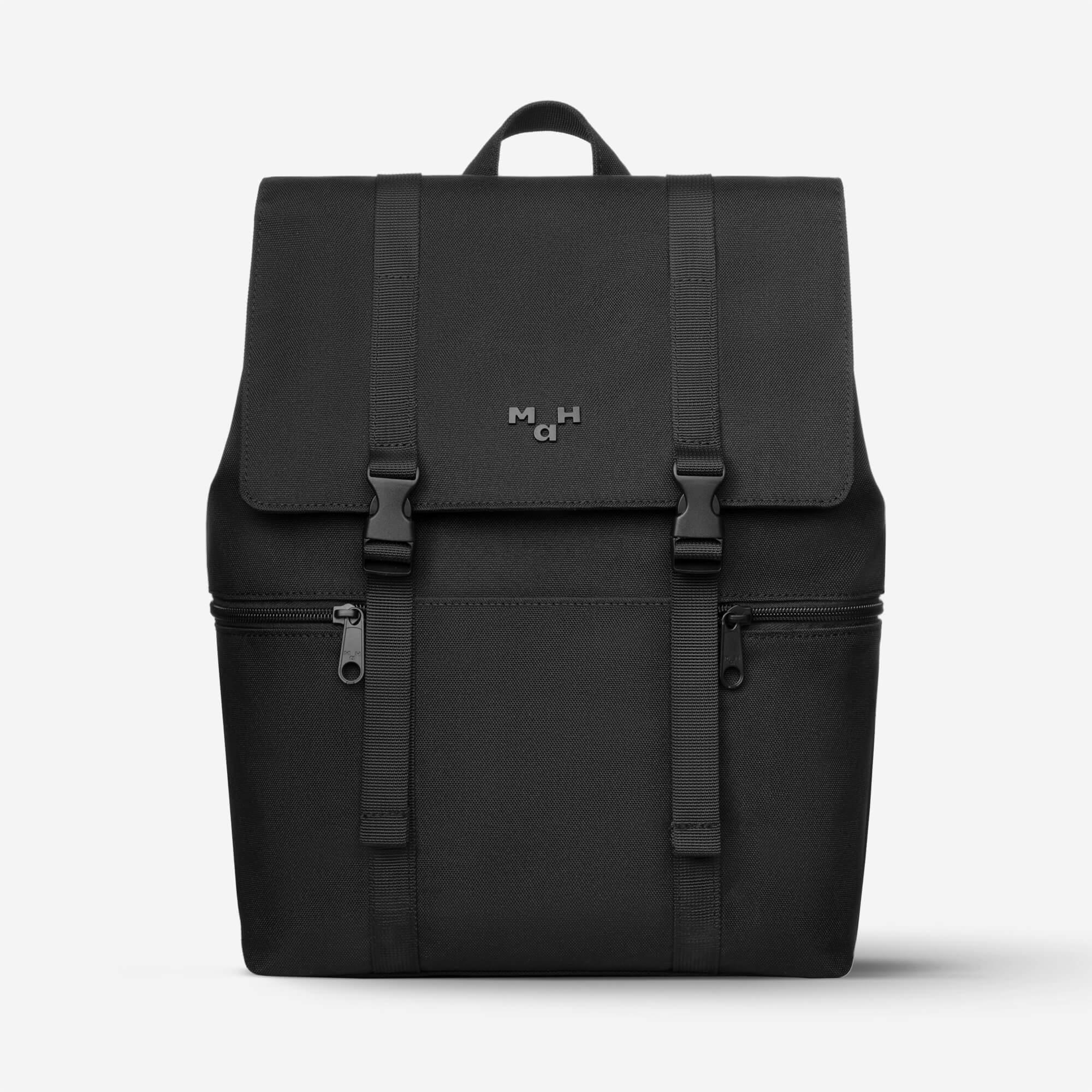 Black minimalist backpack with front flap, buckles, and dual zippers for everyday carry