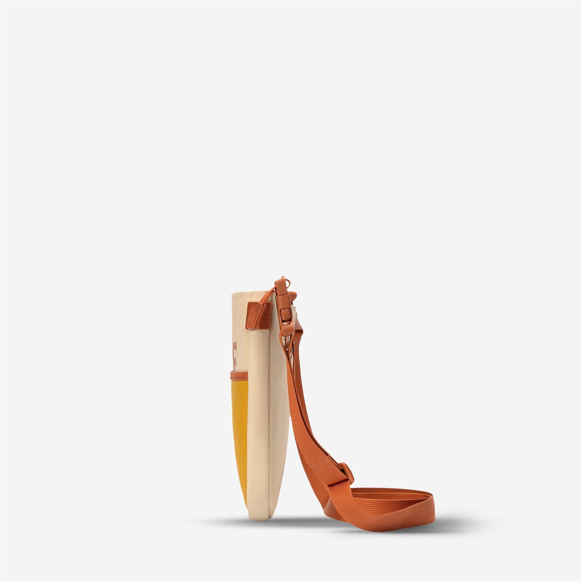 Cream and yellow canvas crossbody bag with orange strap and buckle detail