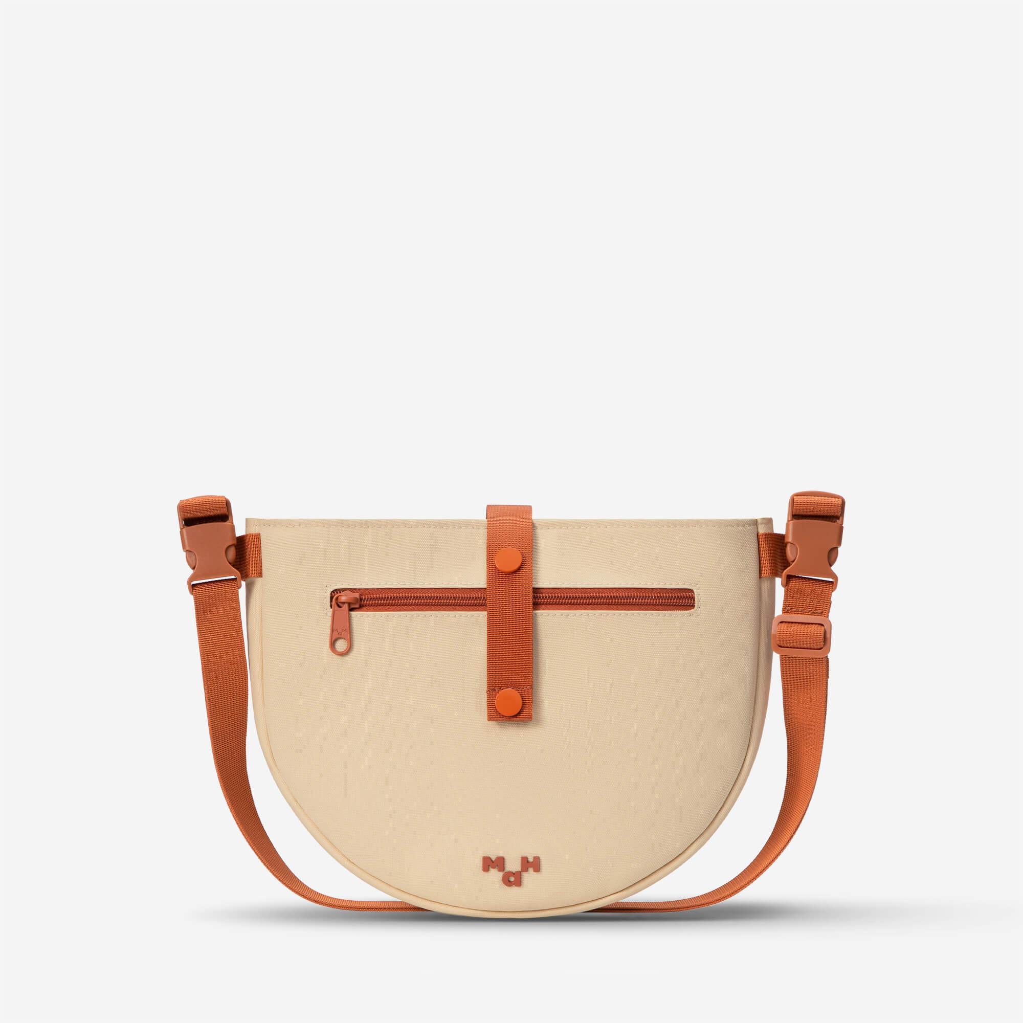 Beige and orange half-moon crossbody bag with front zipper pocket and adjustable strap
