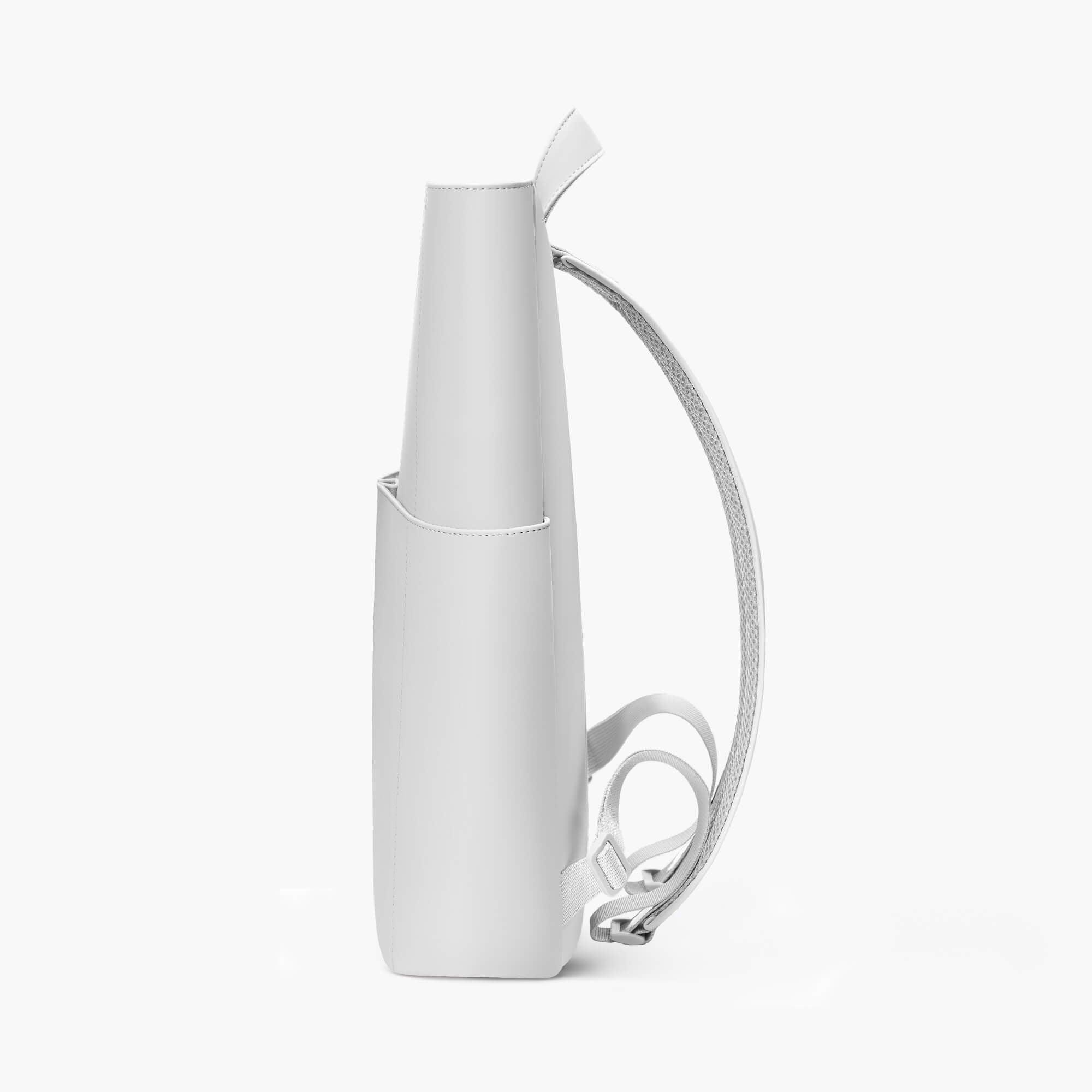 Minimalist white backpack with side pocket and adjustable straps, sleek design for everyday use