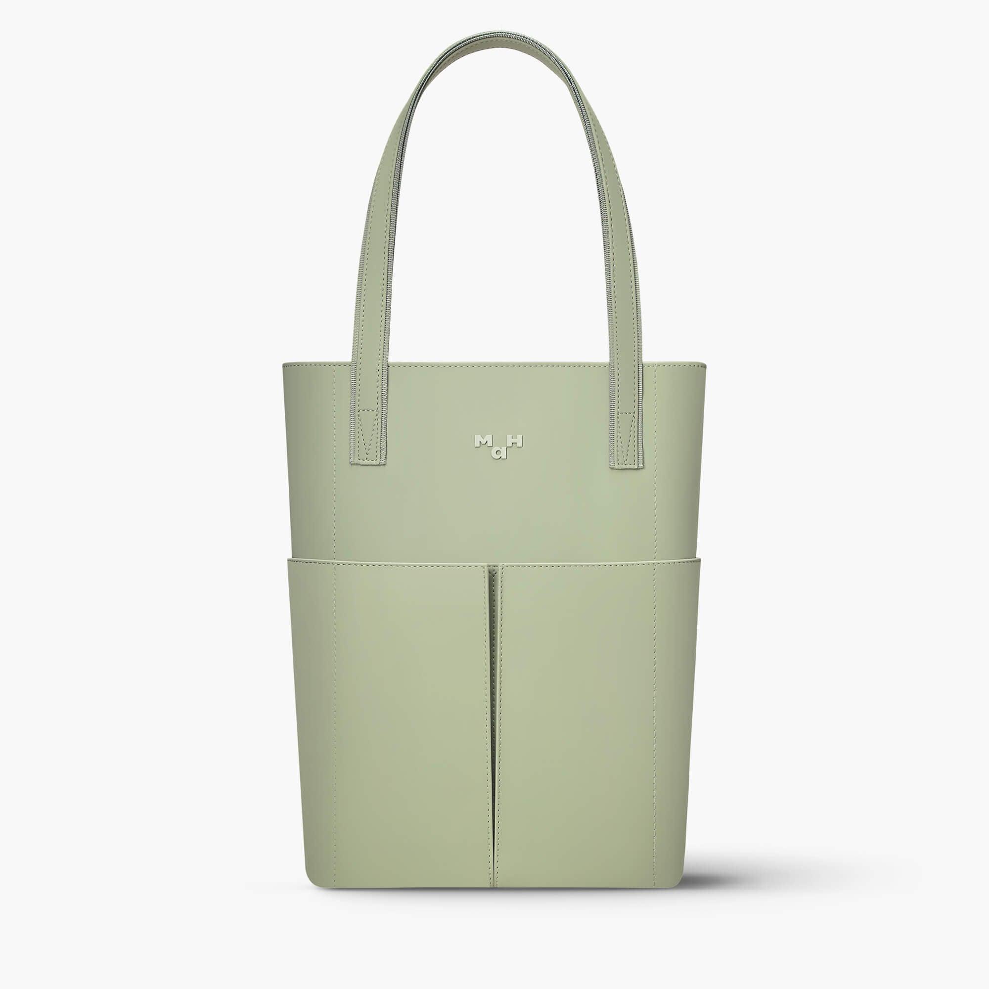 Sage green minimalist tote bag with front pockets and sleek handles, ideal for everyday carry.