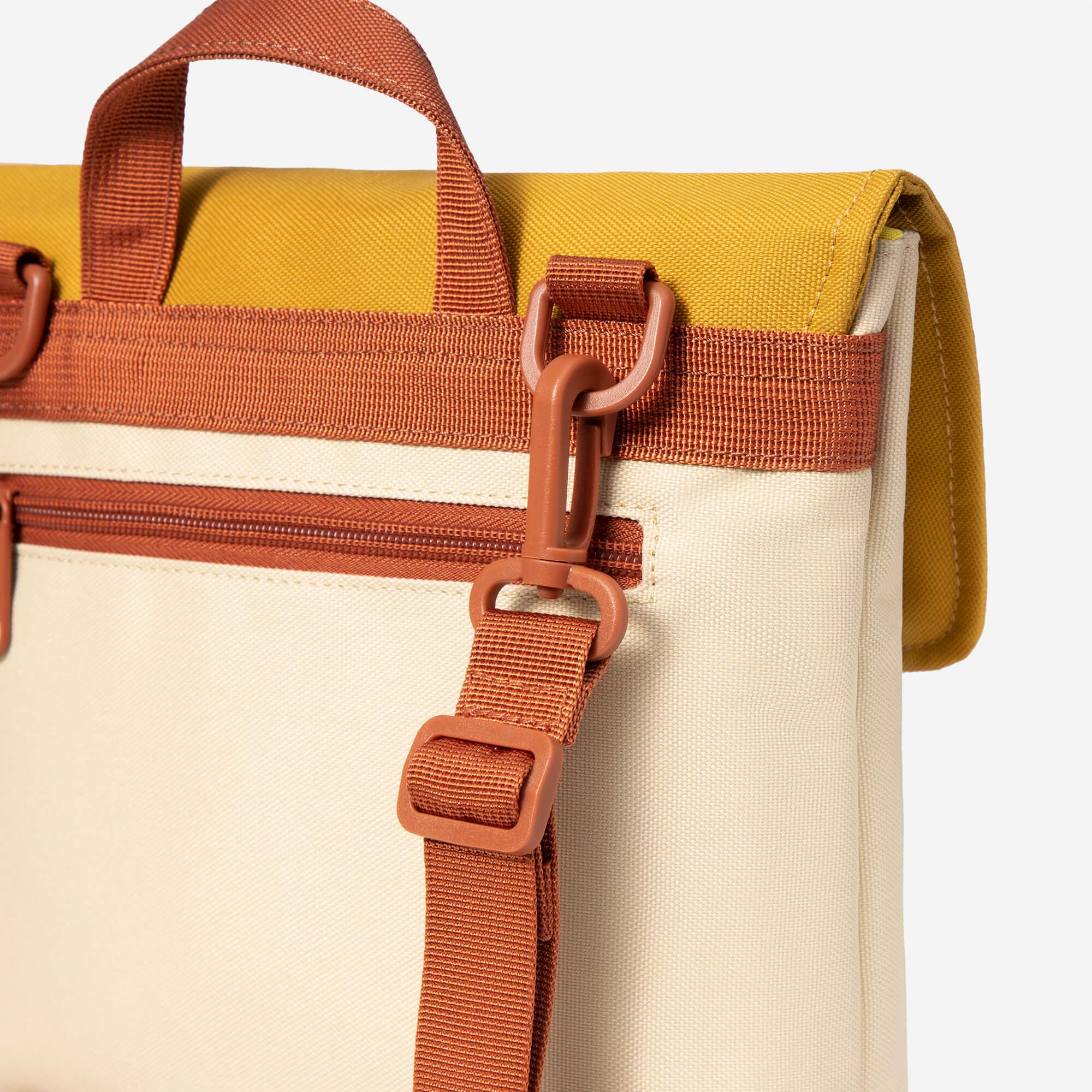 Mustard and cream canvas bag with rust-colored straps and zipper detail