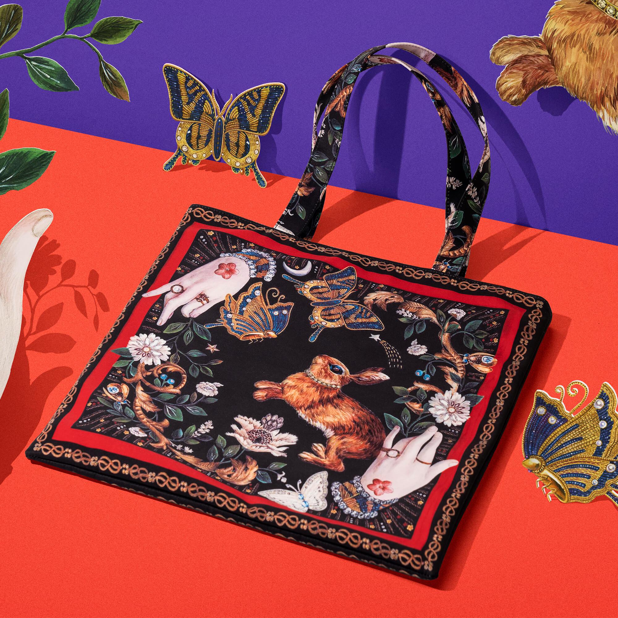 Fantasy tote bag with rabbit, hands, butterflies, and floral print on black background