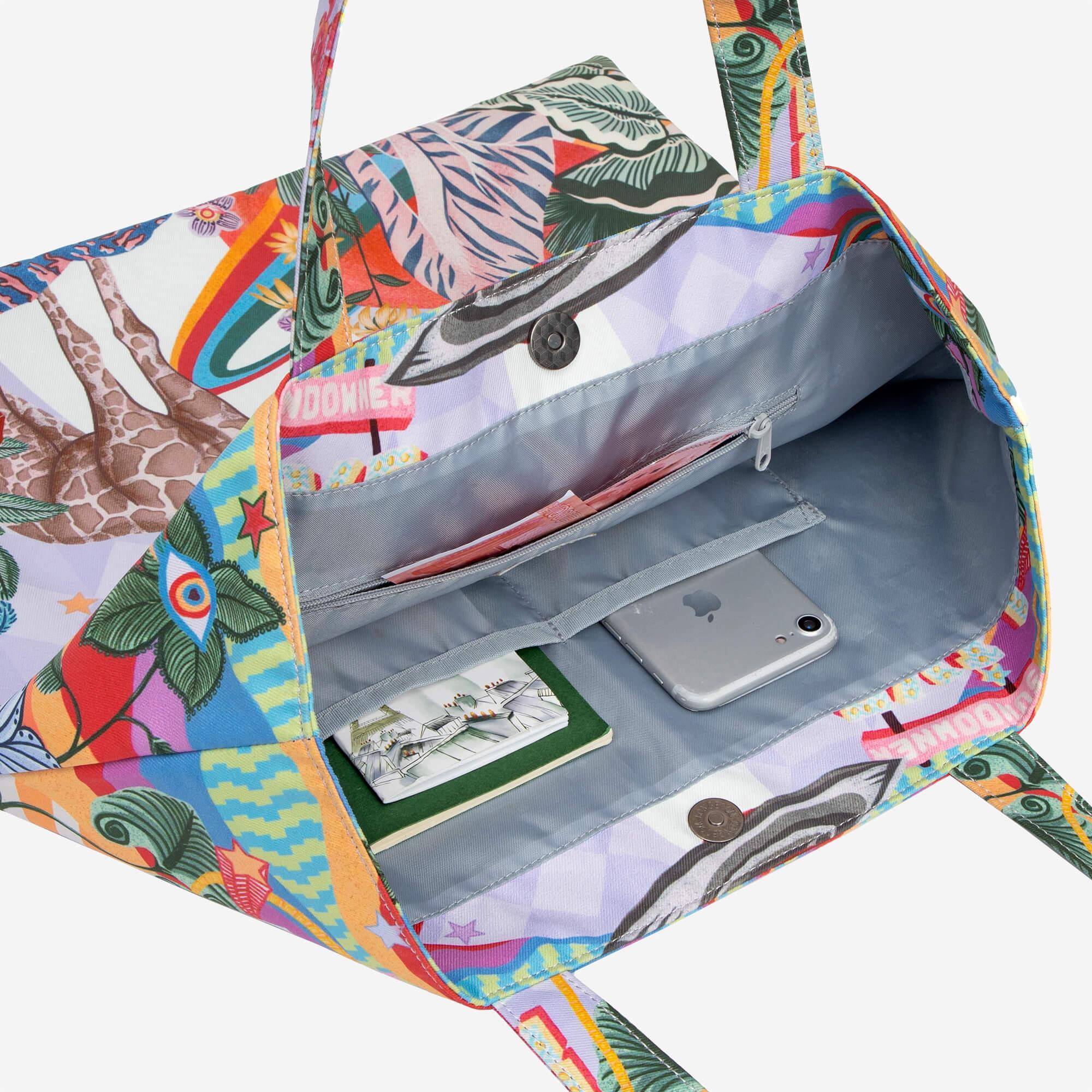 Colorful tropical print tote bag with interior pockets holding phone and notebook, ideal for daily use.