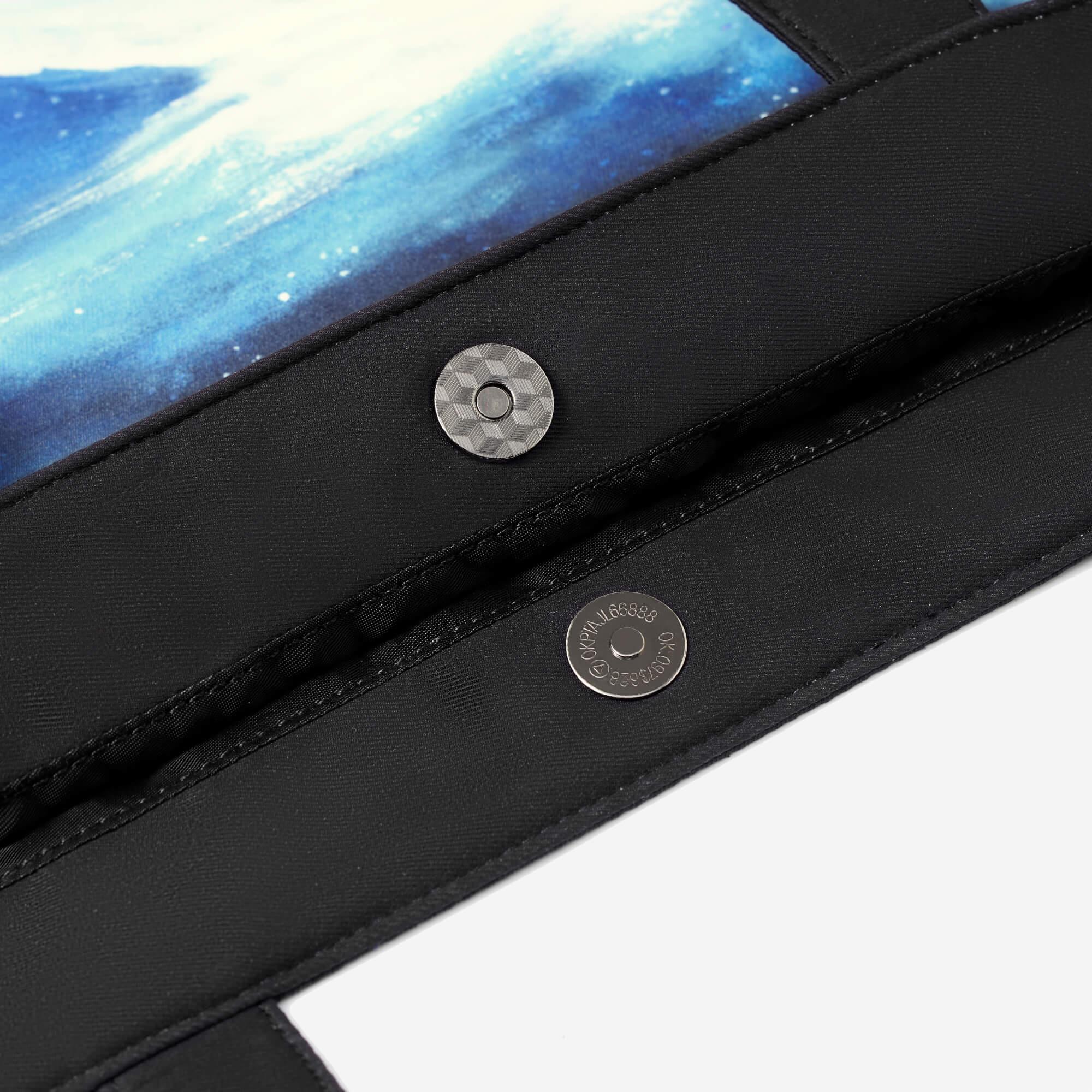 Black fabric bag with blue galaxy print and silver snap buttons, stylish accessory detail