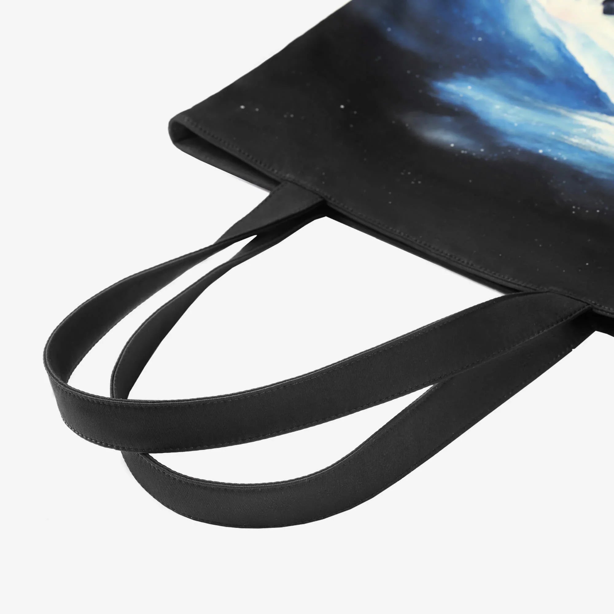 Black tote bag with cosmic galaxy print, long handles, and starry night design for everyday use.