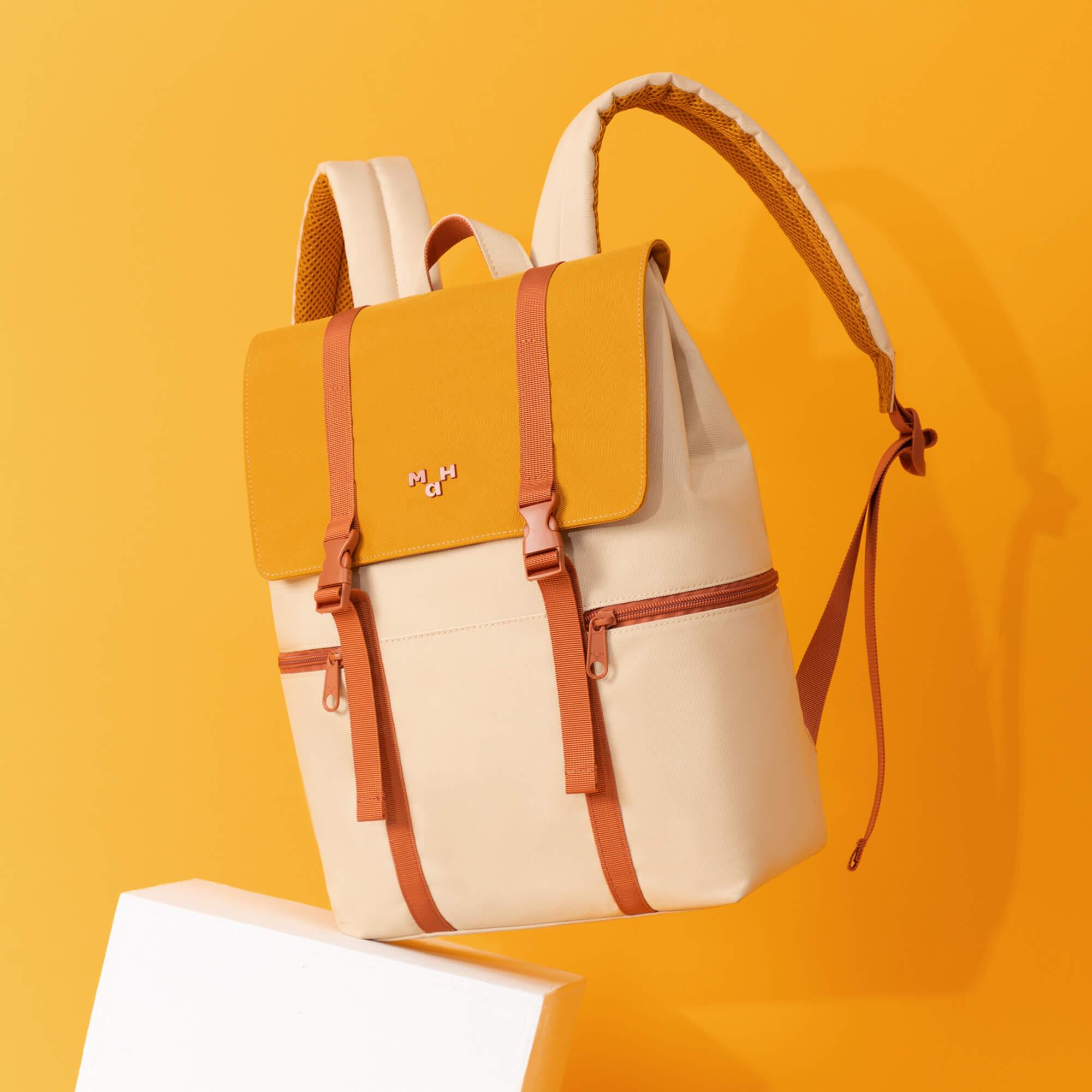 Stylish yellow and cream backpack with orange straps, perfect for daily use or travel