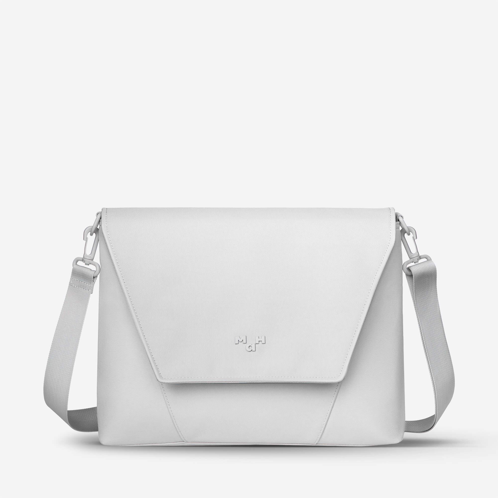 White minimalist crossbody bag with adjustable strap and sleek flap design, ideal for everyday use.