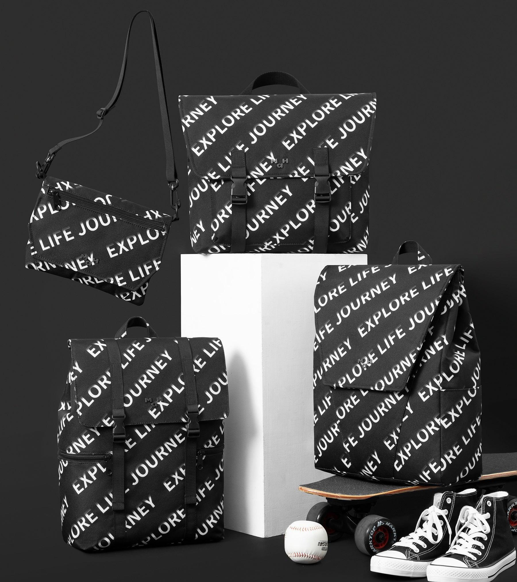 Black and white 'Explore Life Journey' print backpacks, crossbody bag, sneakers, skateboard, and baseball on display