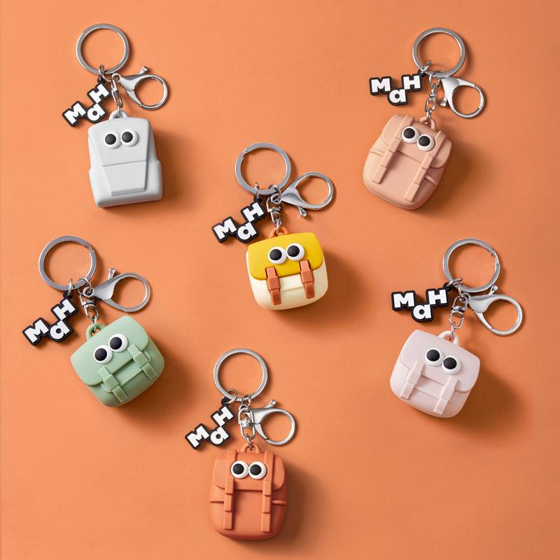 Cute backpack keychains with googly eyes in pastel colors, perfect for bags and accessories.
