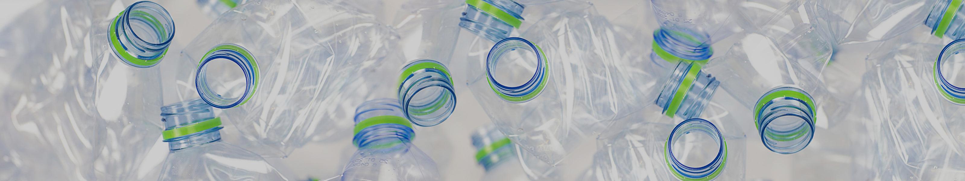 Clear plastic water bottles with green and blue caps, eco-friendly material for sustainable lifestyle products.