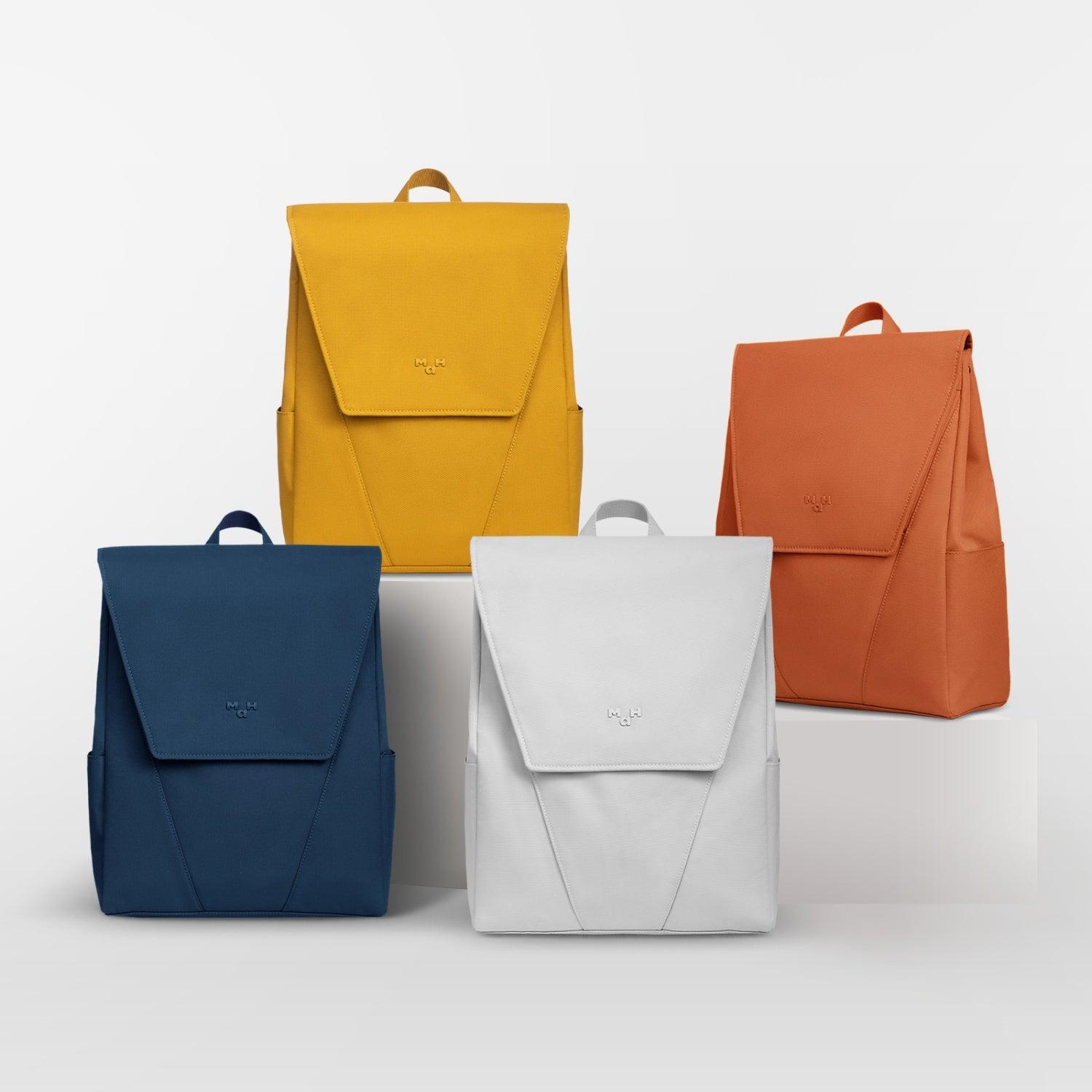 Modern minimalist backpacks in yellow, orange, blue, and white with sleek design and subtle branding