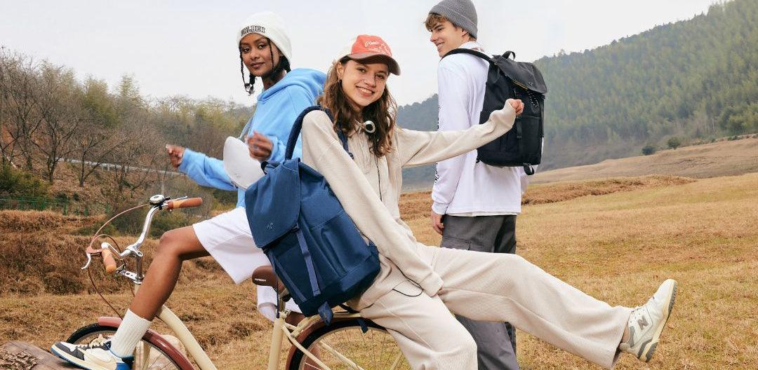 Young friends with stylish backpacks on a bike in nature, perfect for travel and daily use