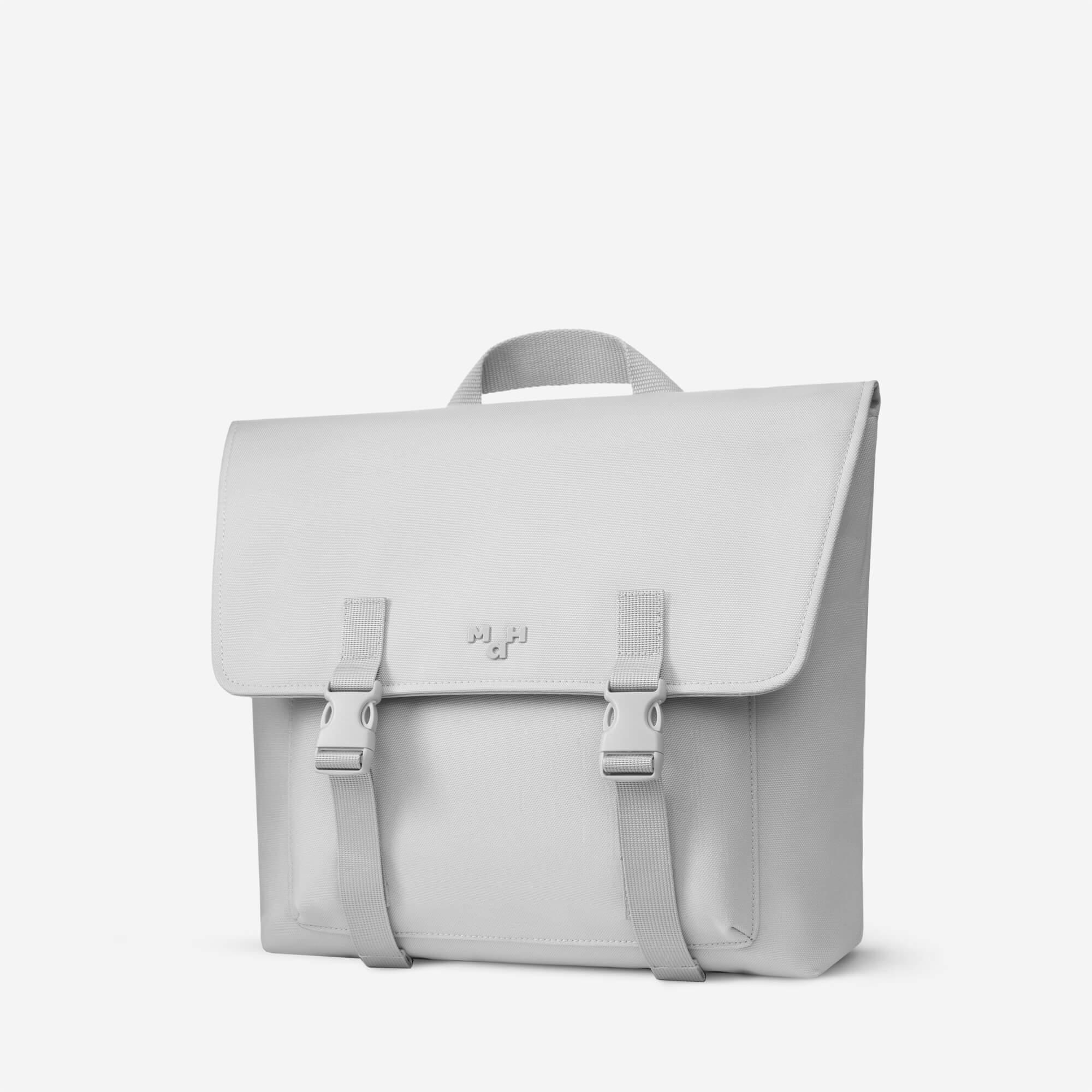Light gray satchel bag with buckle straps and top handle, minimalist design for everyday use