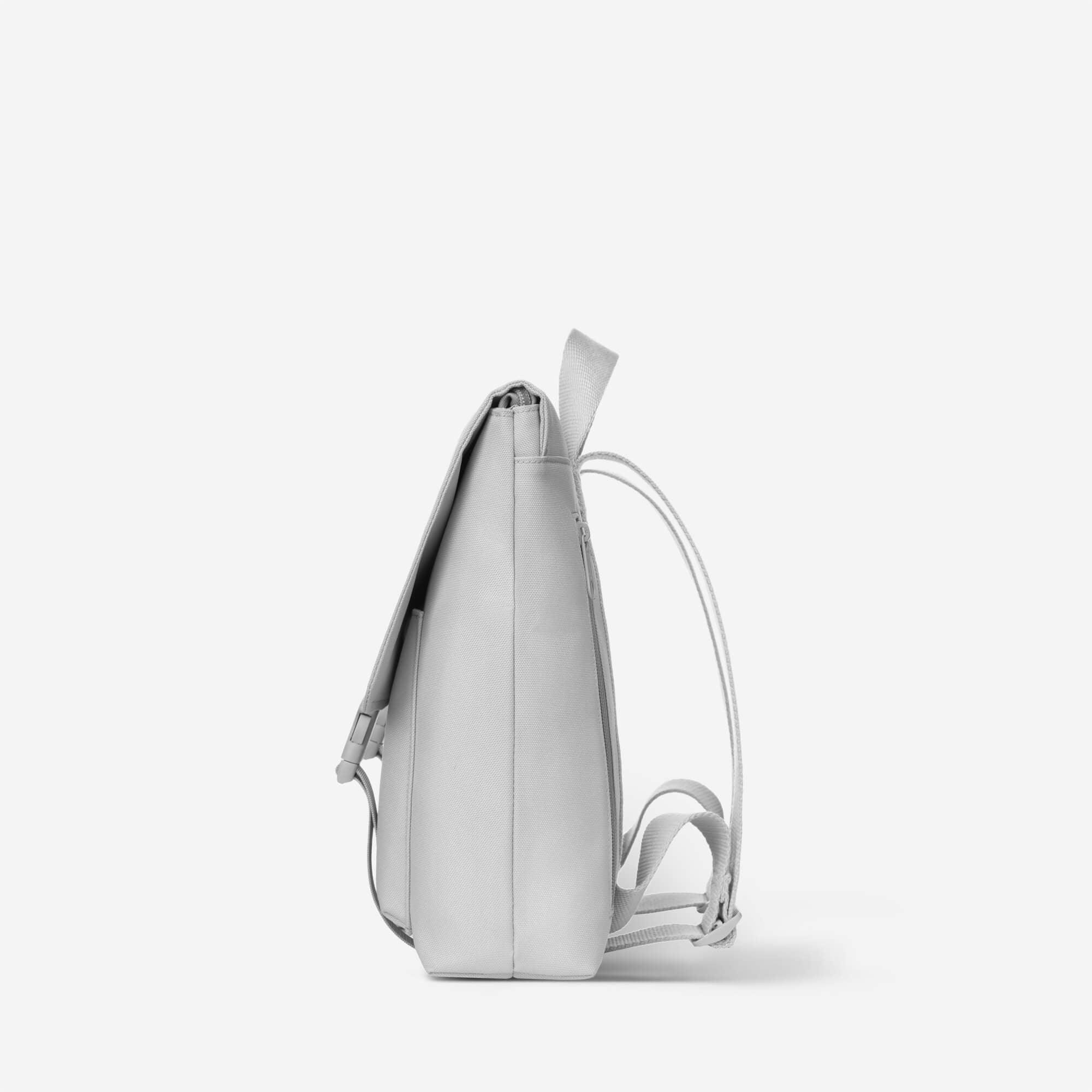 Light gray minimalist backpack with adjustable straps and side pocket, ideal for daily use or travel