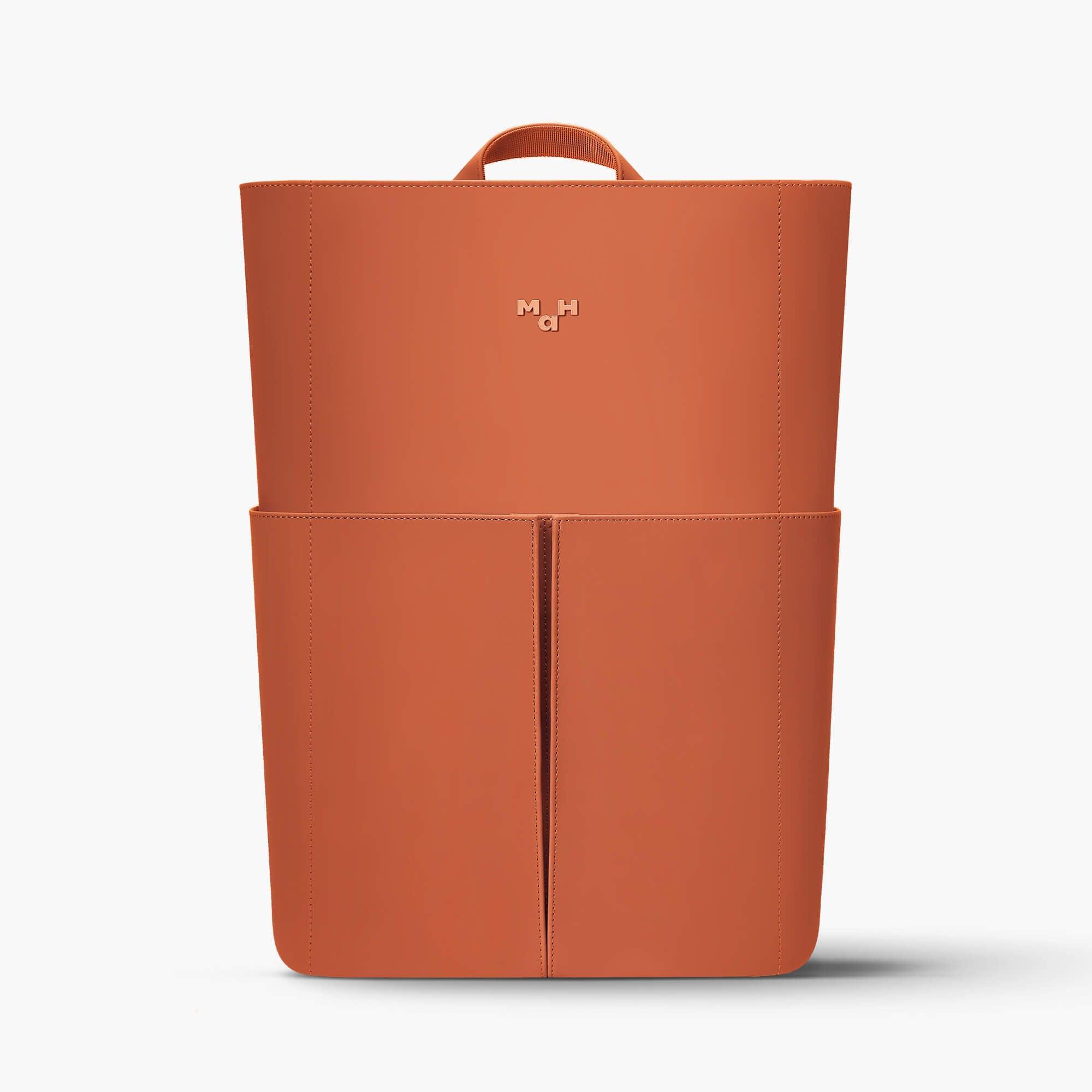 Terracotta leather backpack with front pockets and top handle, minimalist design for everyday use