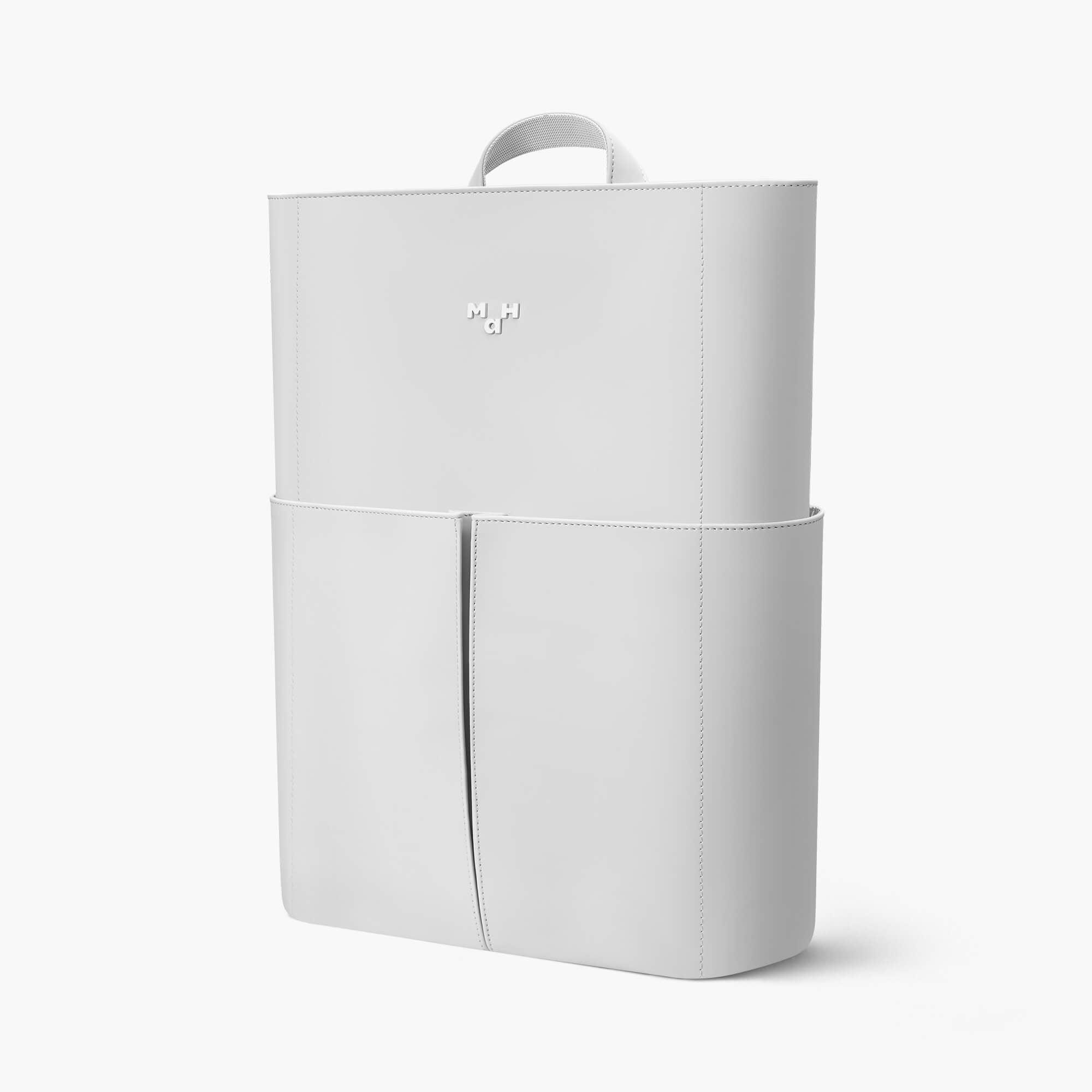 Minimalist white backpack with front pockets and top handle, sleek design for everyday use