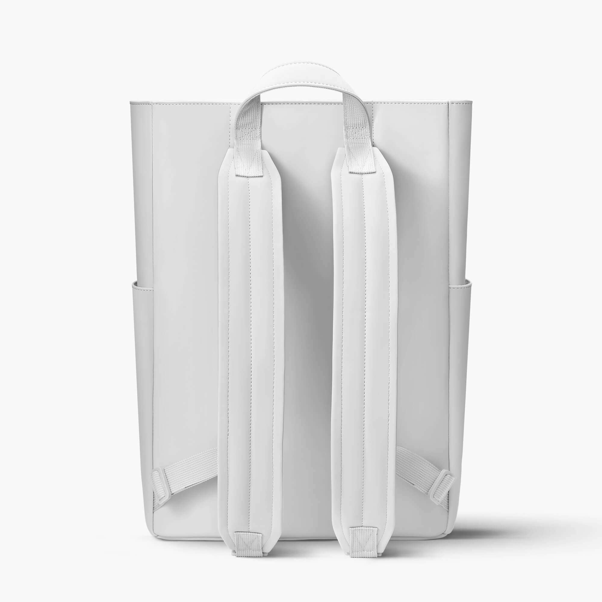 Minimalist white backpack with padded shoulder straps and top handle, ideal for daily use or travel.