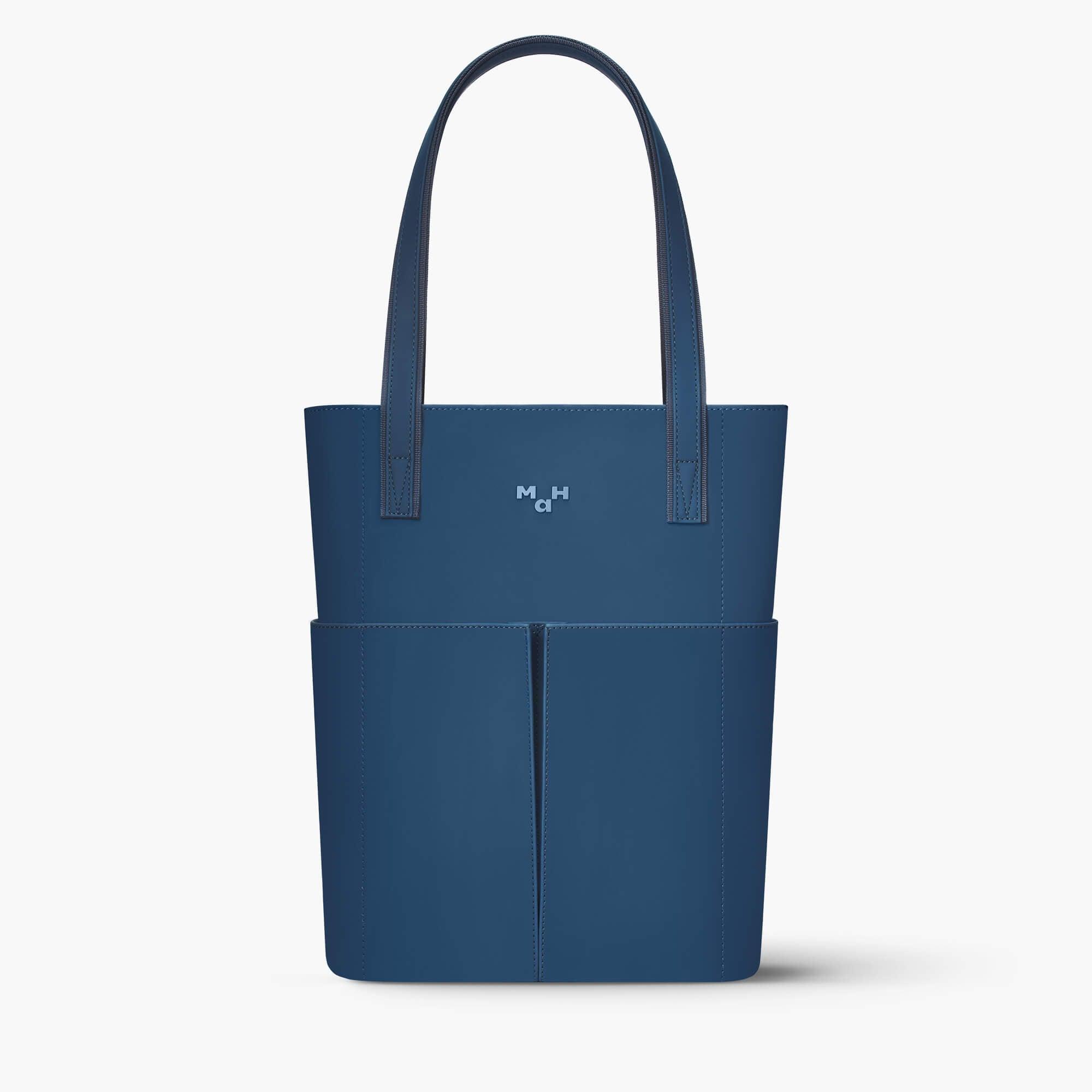 Navy blue tote bag with front pockets and minimalist design, ideal for everyday carry and lifestyle use.