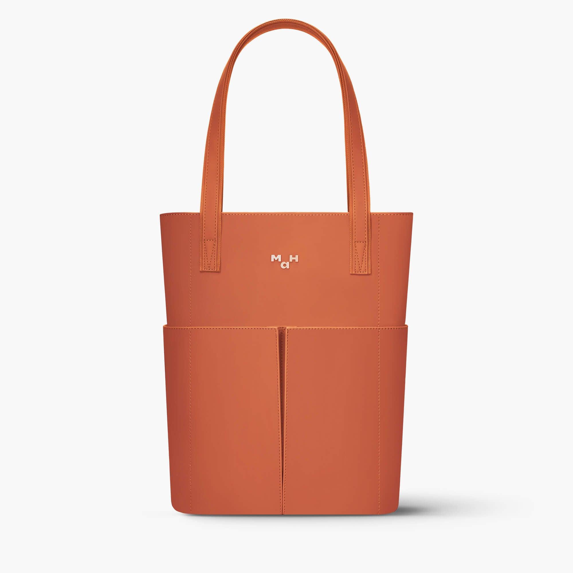 Rust orange tote bag with front pockets and minimalist design, ideal for everyday carry and lifestyle use.