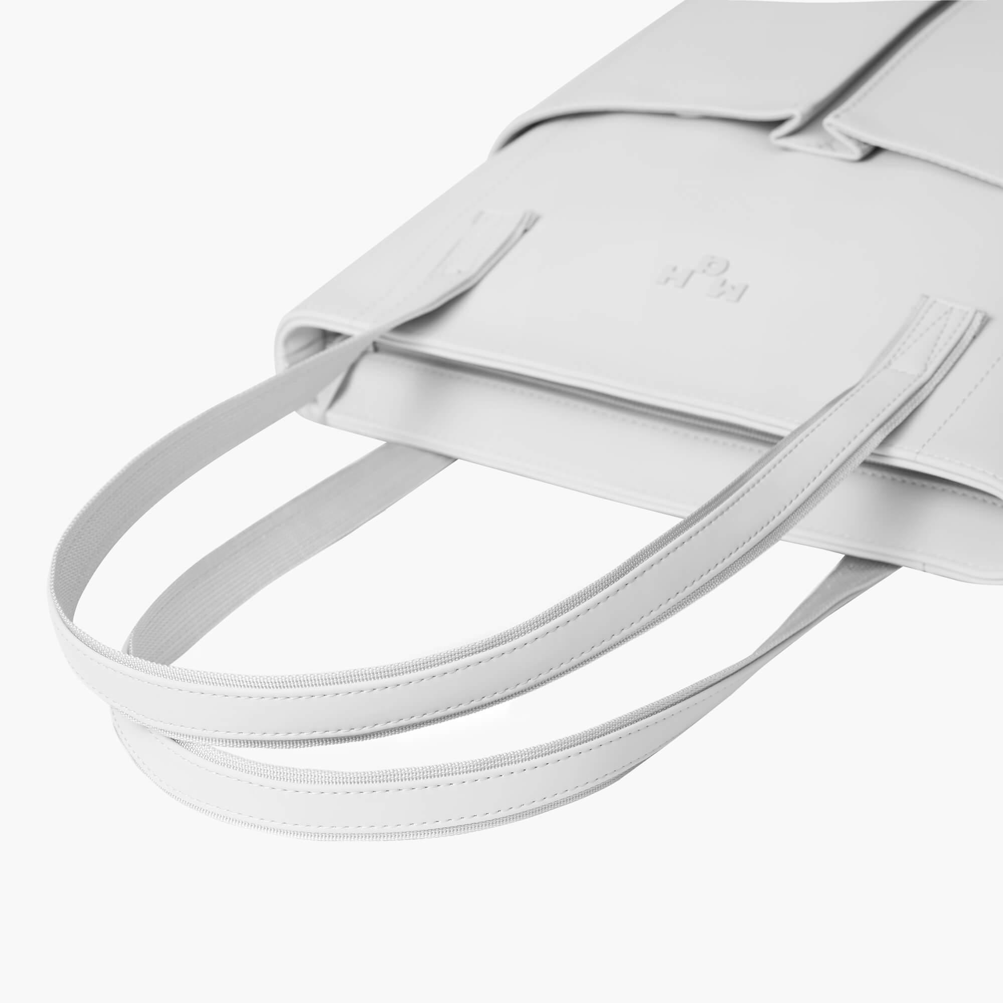 Minimalist white leather tote bag with sleek straps and clean stitching details