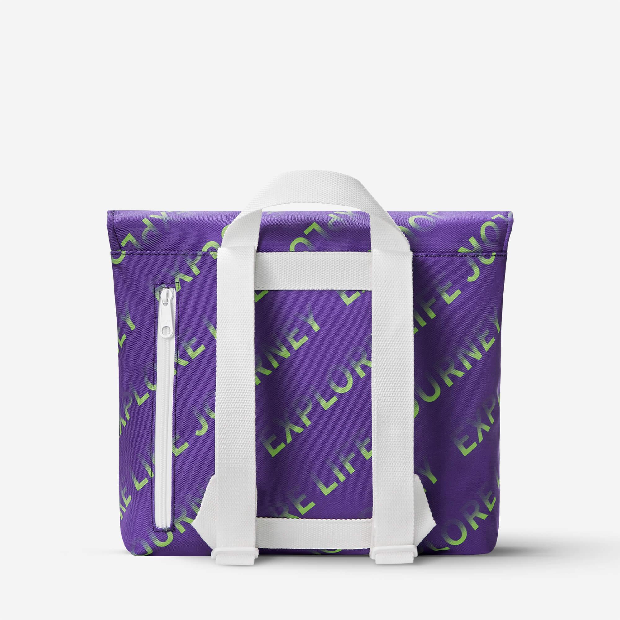 Purple tote bag with green 'Explore Life Journey' print, white straps, and front zipper pocket