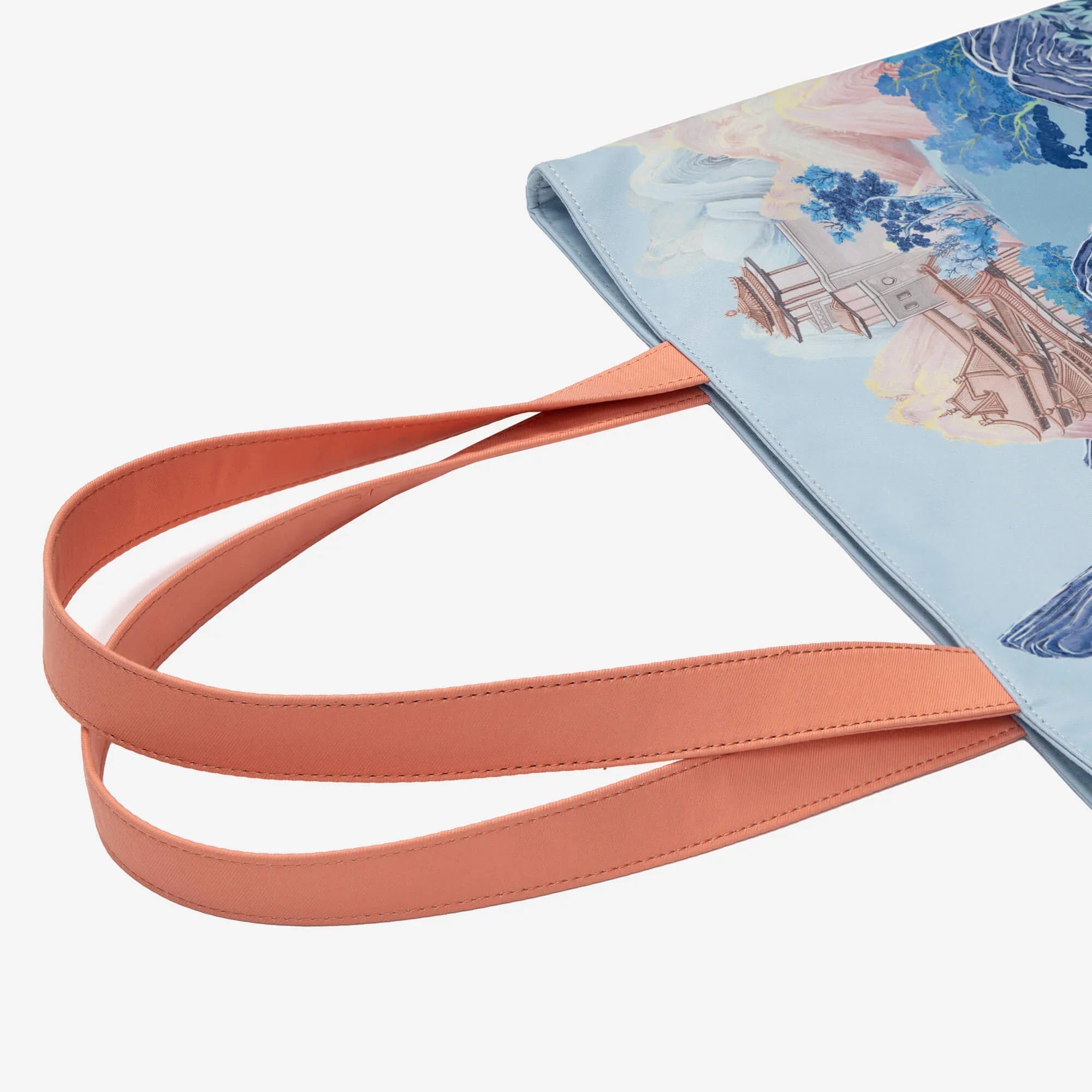Light blue tote bag with scenic landscape print and peach straps, ideal for everyday carry and stylish accessories.