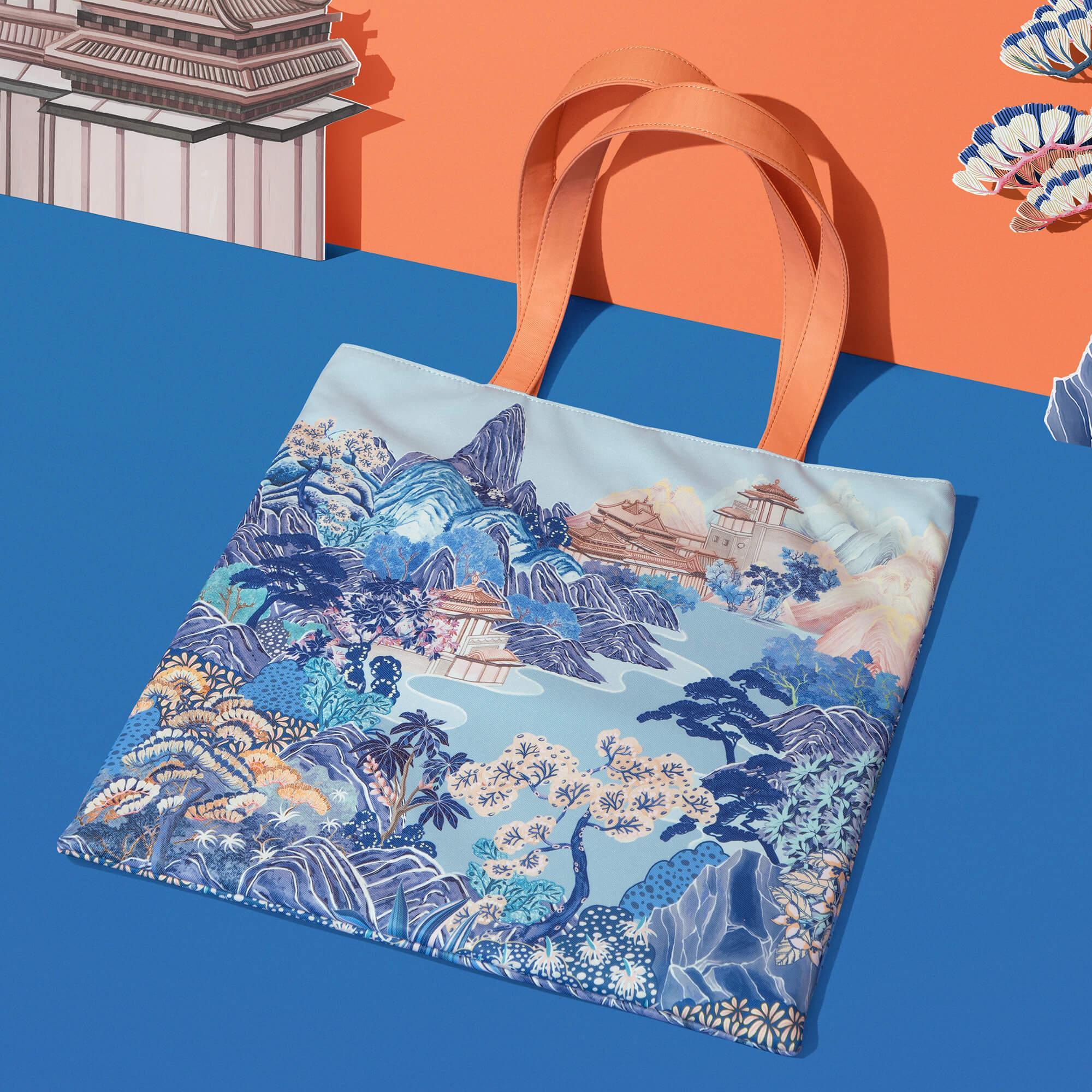 Tote bag with Japanese landscape print, orange handles, blue background, ideal for everyday use and travel