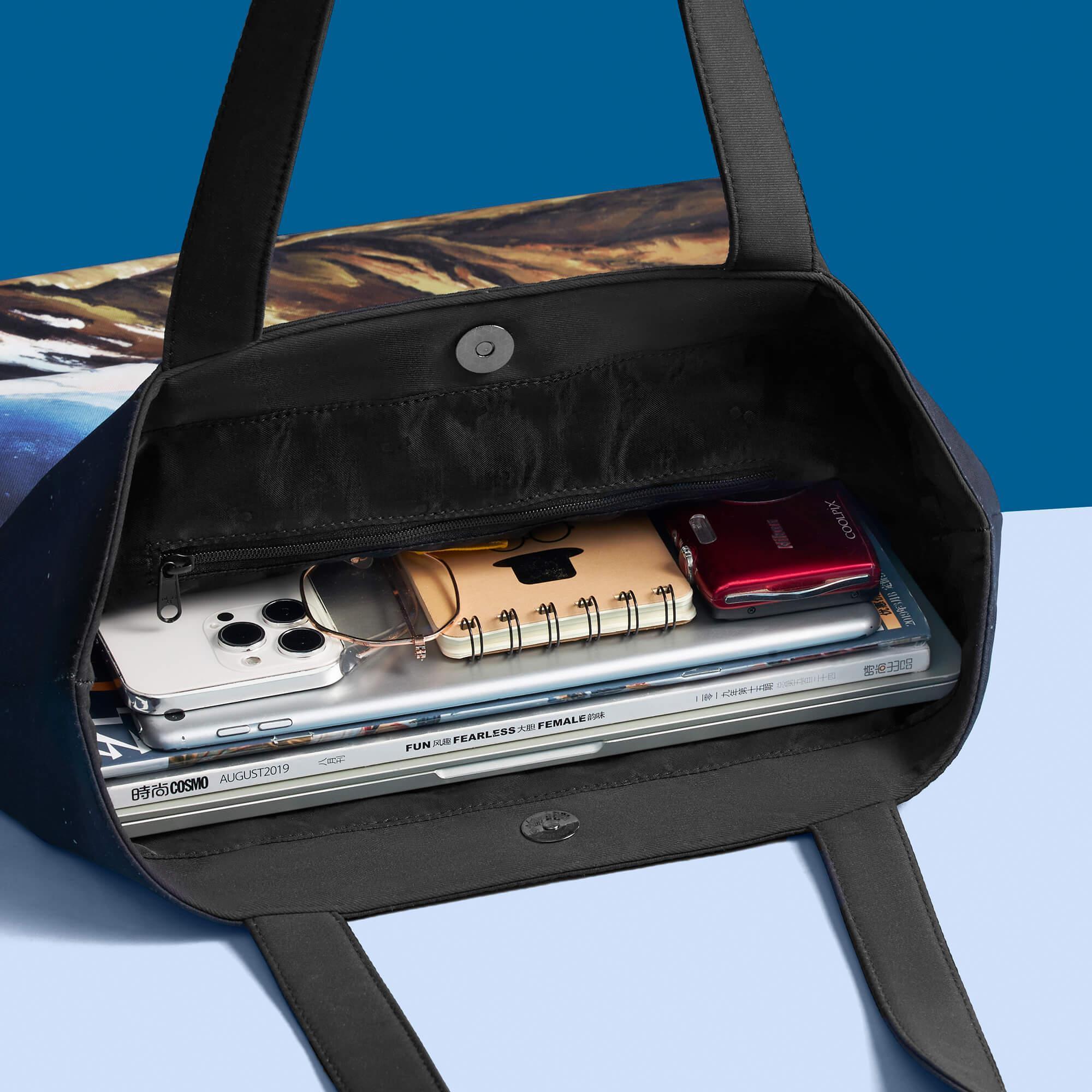 Spacious tote bag with laptop, phone, notebook, and magazines inside, ideal for daily essentials and travel.