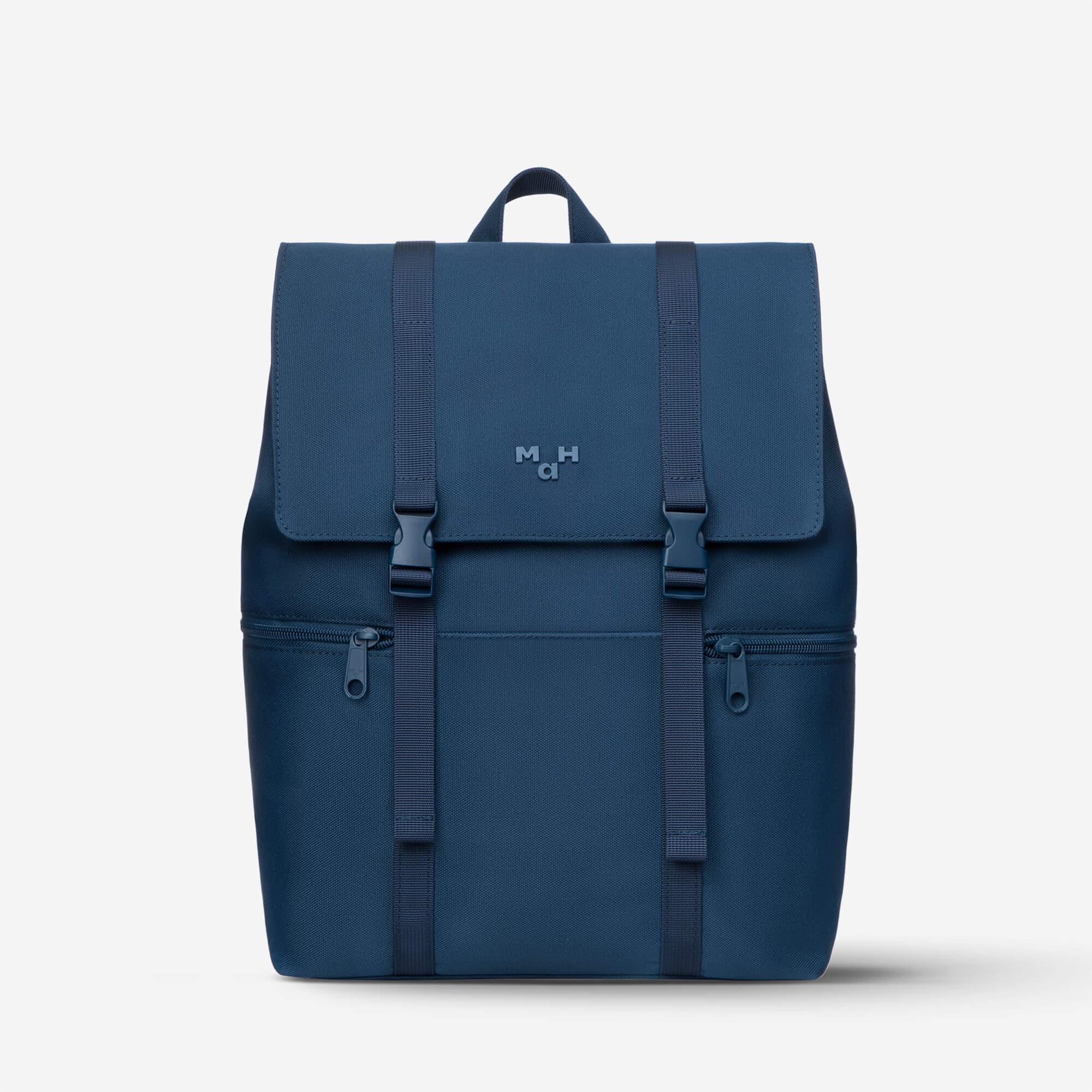 Navy blue backpack with front flap, dual straps, and side zip pockets, featuring minimalist design and subtle logo.