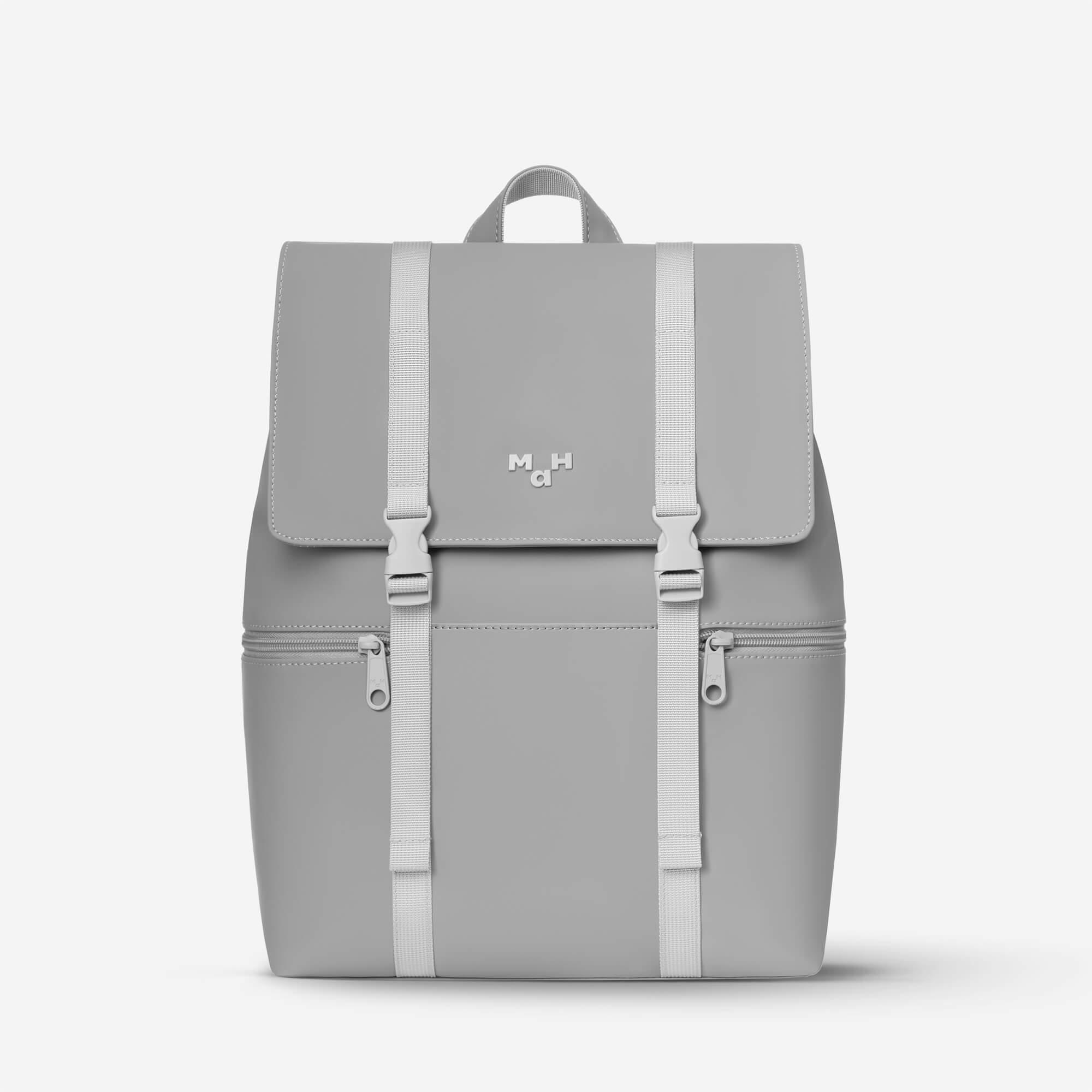 Light gray minimalist backpack with front flap, dual straps, and zippered pockets, ideal for daily use or travel.