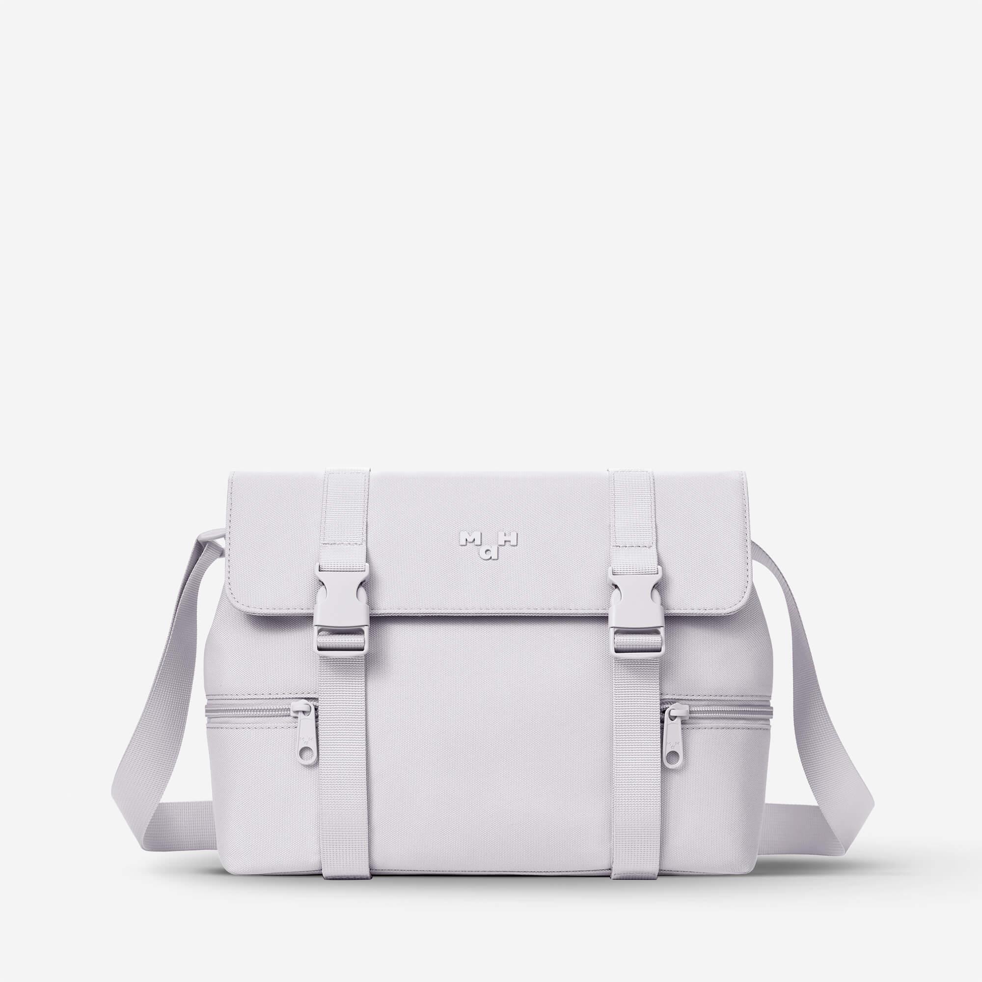 White minimalist satchel bag with adjustable straps and front zippers, ideal for everyday carry