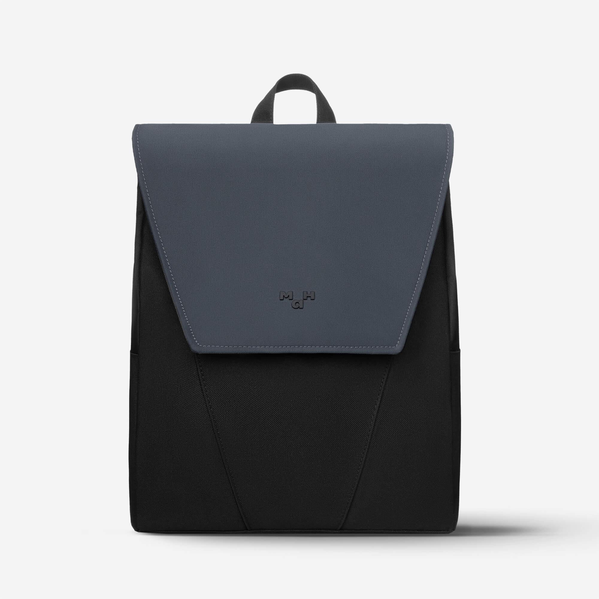 Modern black and gray backpack with flap closure and top handle, ideal for daily use or travel.