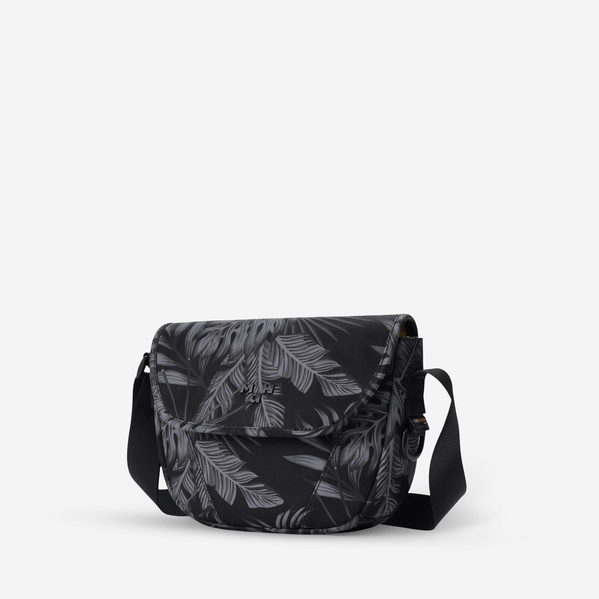Black crossbody bag with gray leaf print, adjustable strap, and front flap closure