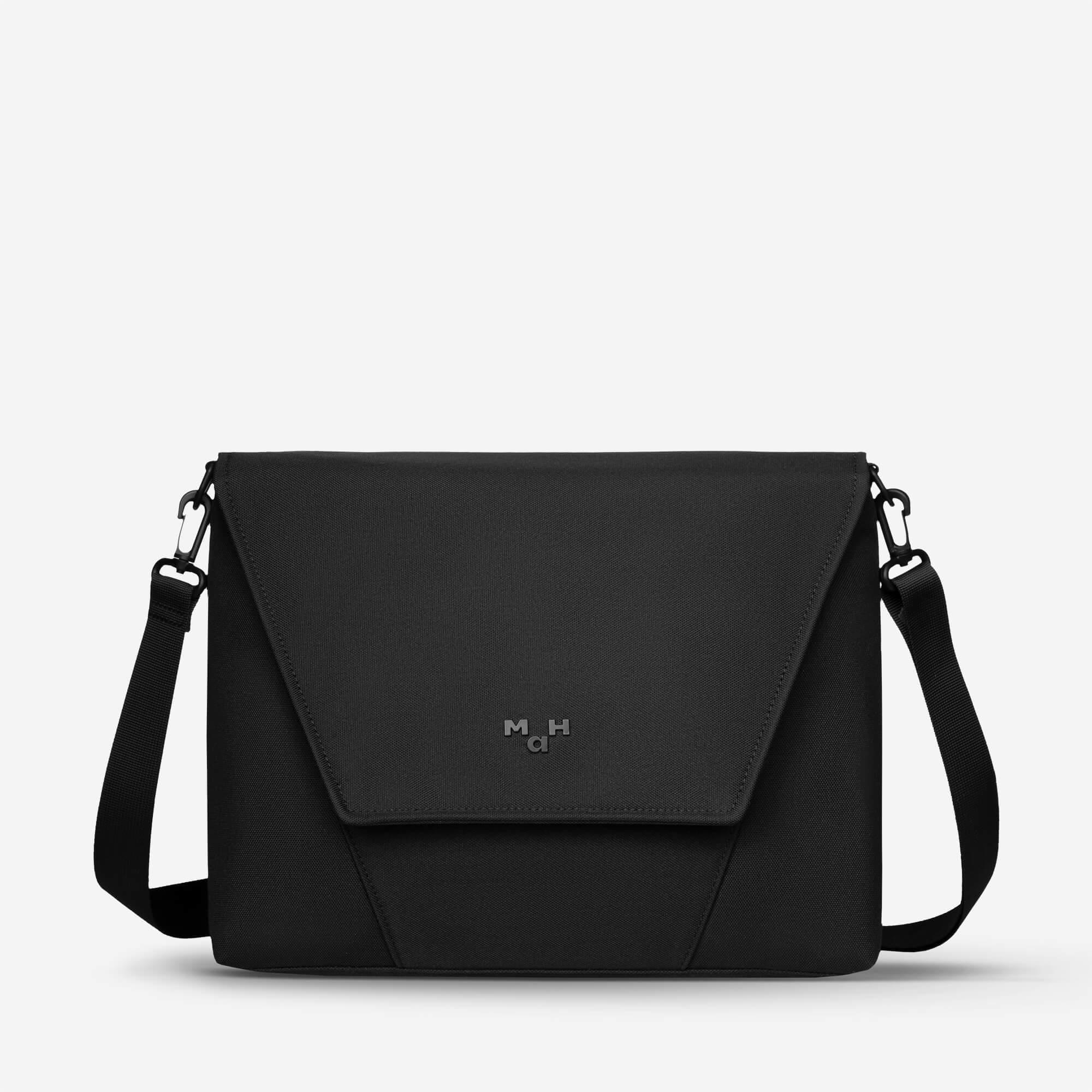 Black minimalist messenger bag with adjustable strap and subtle logo, ideal for everyday carry and urban style.
