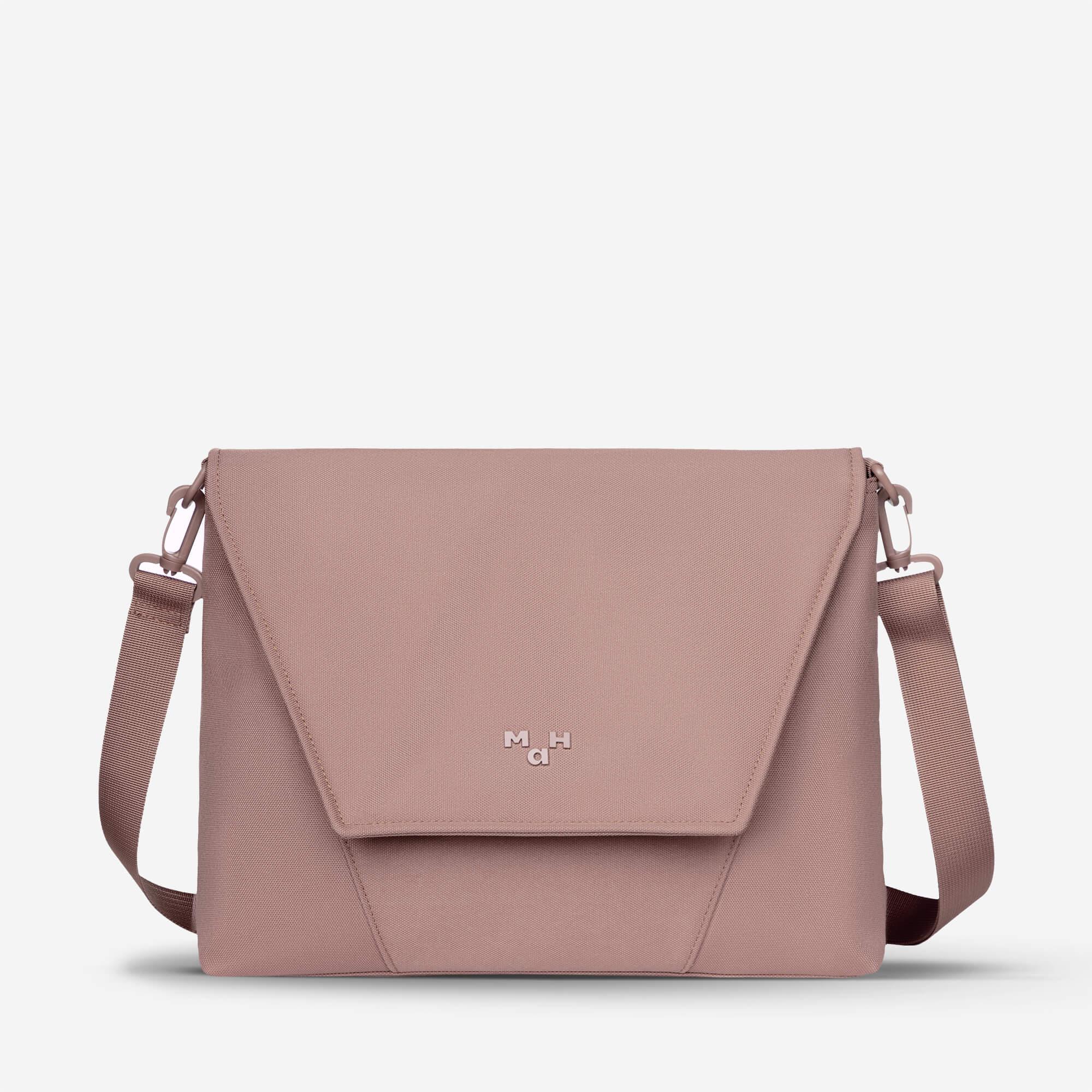 Dusty rose crossbody bag with flap closure and adjustable strap, featuring minimalist design and subtle logo.