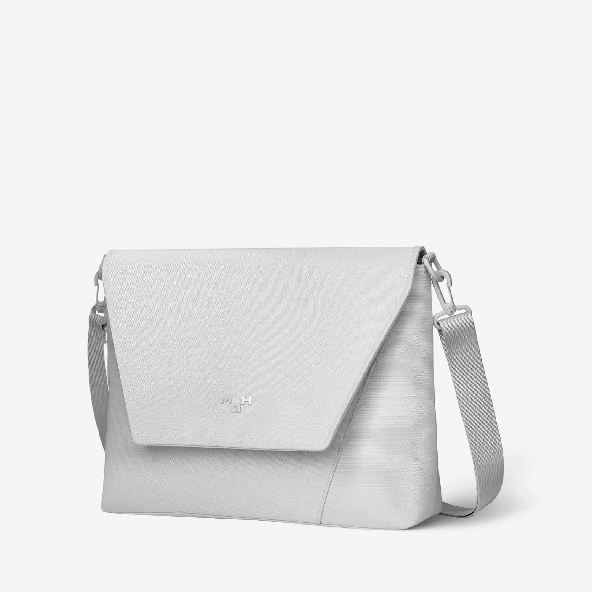 Light gray minimalist crossbody bag with adjustable strap and subtle logo, ideal for everyday use