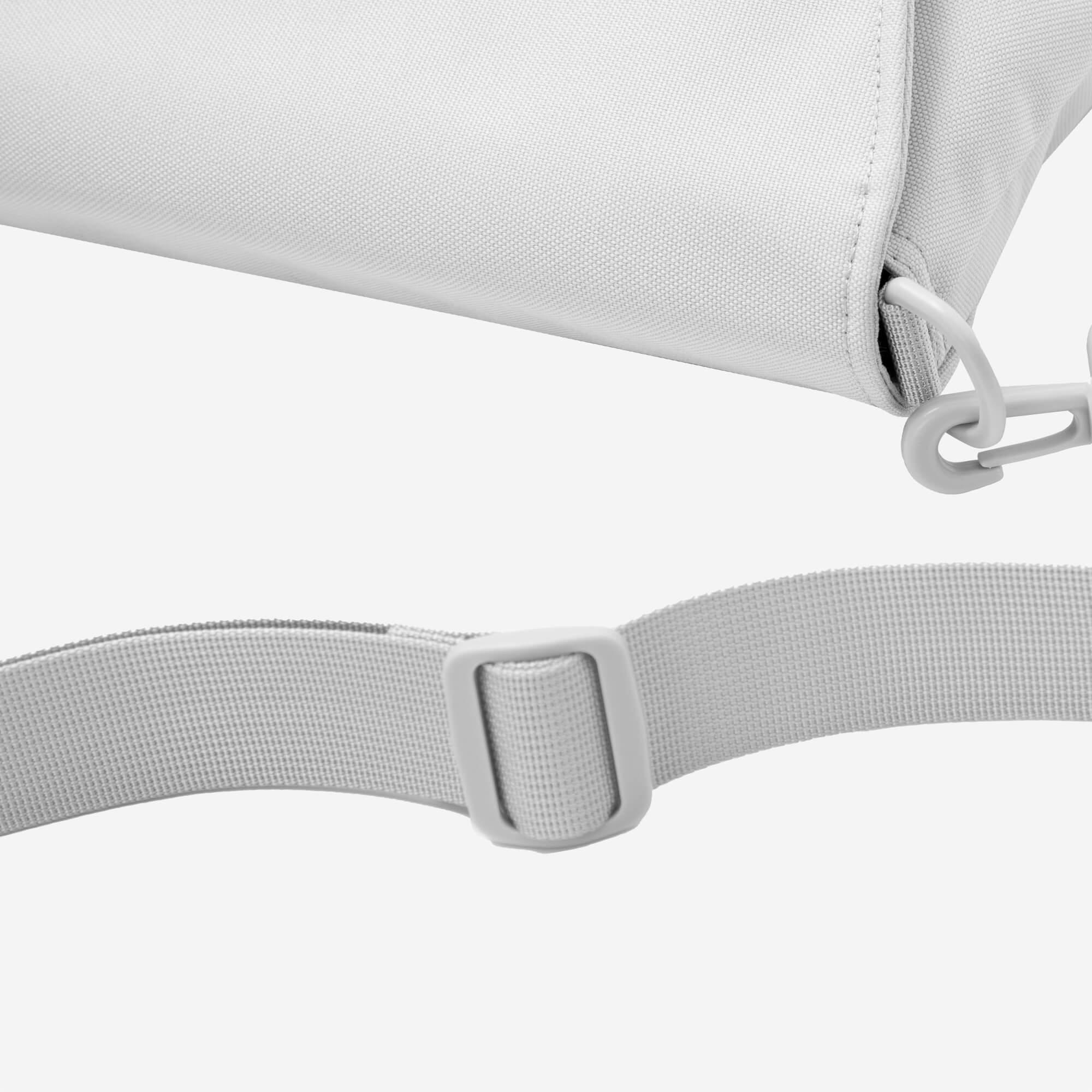 Light gray canvas bag with adjustable strap and plastic buckle detail