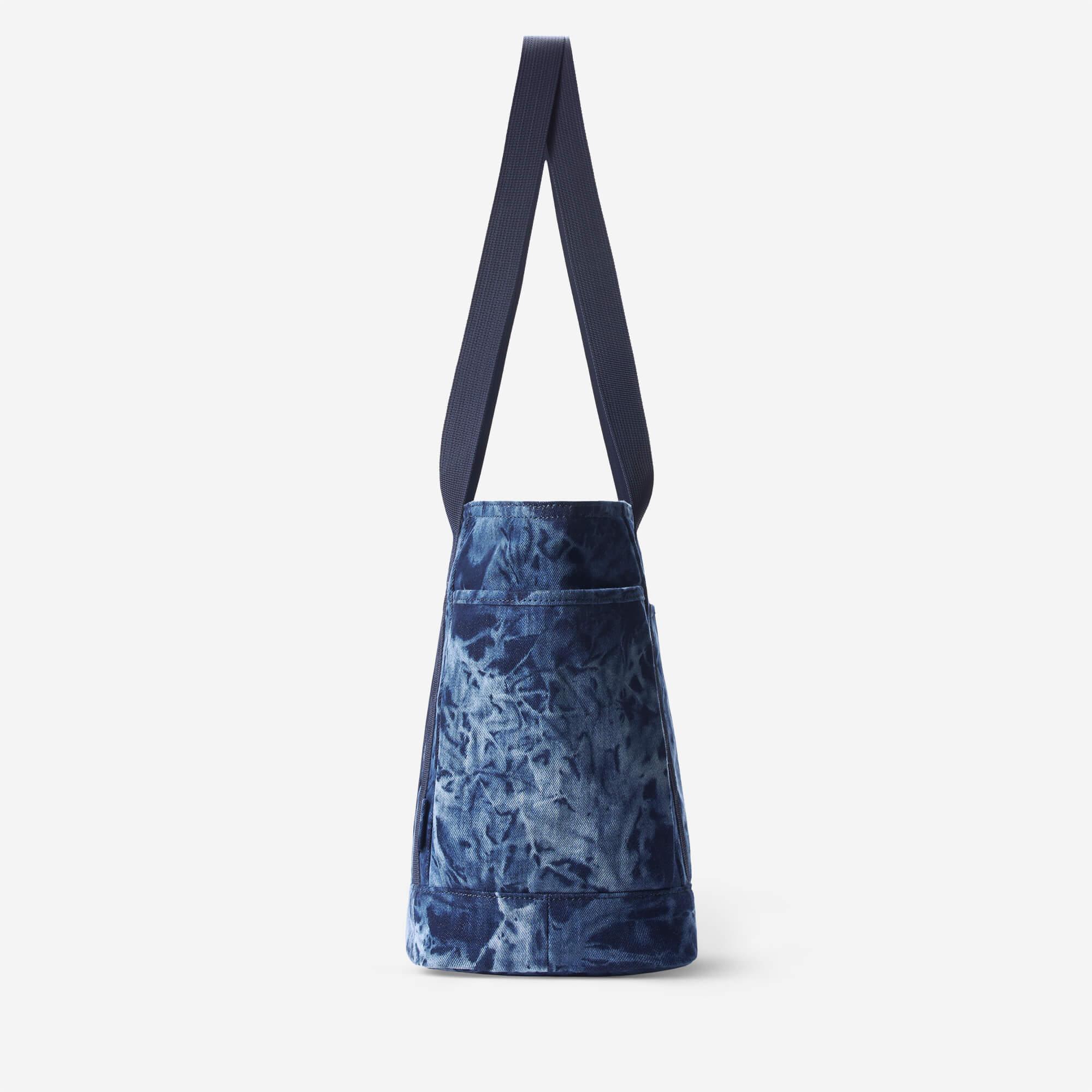 Blue tie-dye tote bag with long shoulder strap and front pocket, ideal for everyday carry