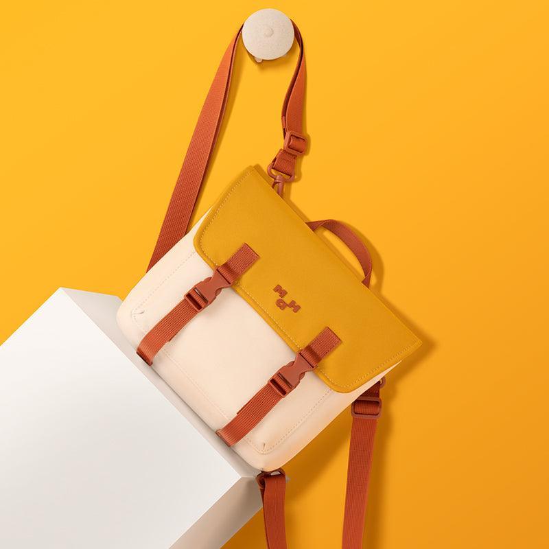 Stylish two-tone backpack with mustard yellow flap and rust straps, modern design for everyday use