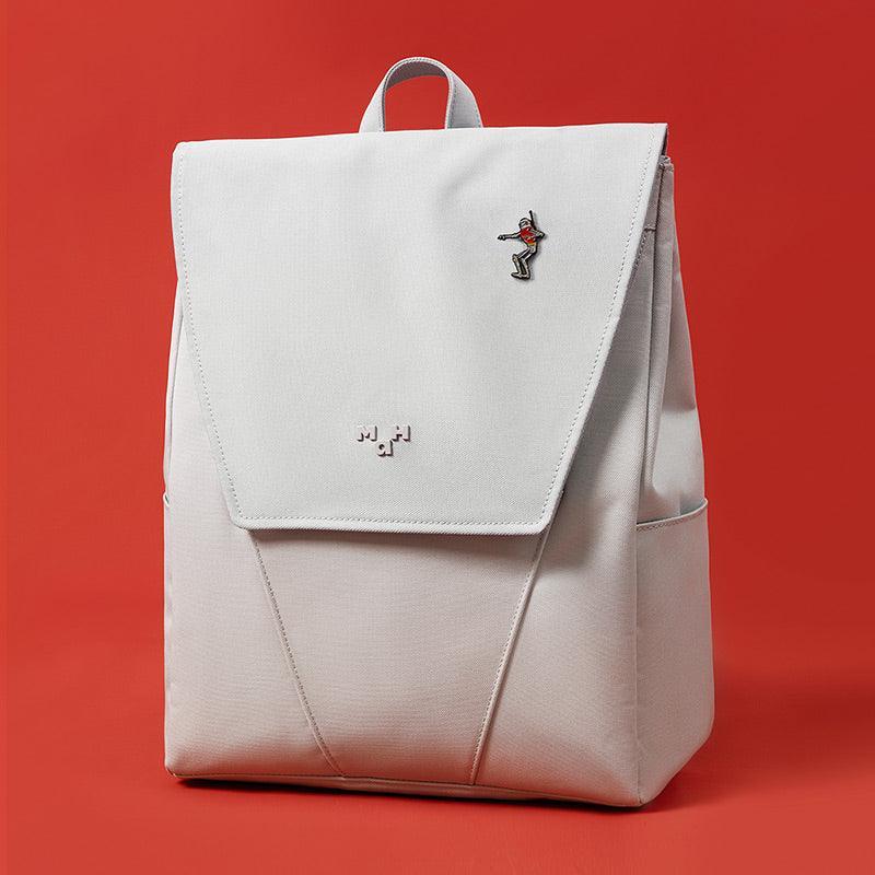 Light gray minimalist backpack with front flap, small pin, and subtle logo, ideal for daily use or travel